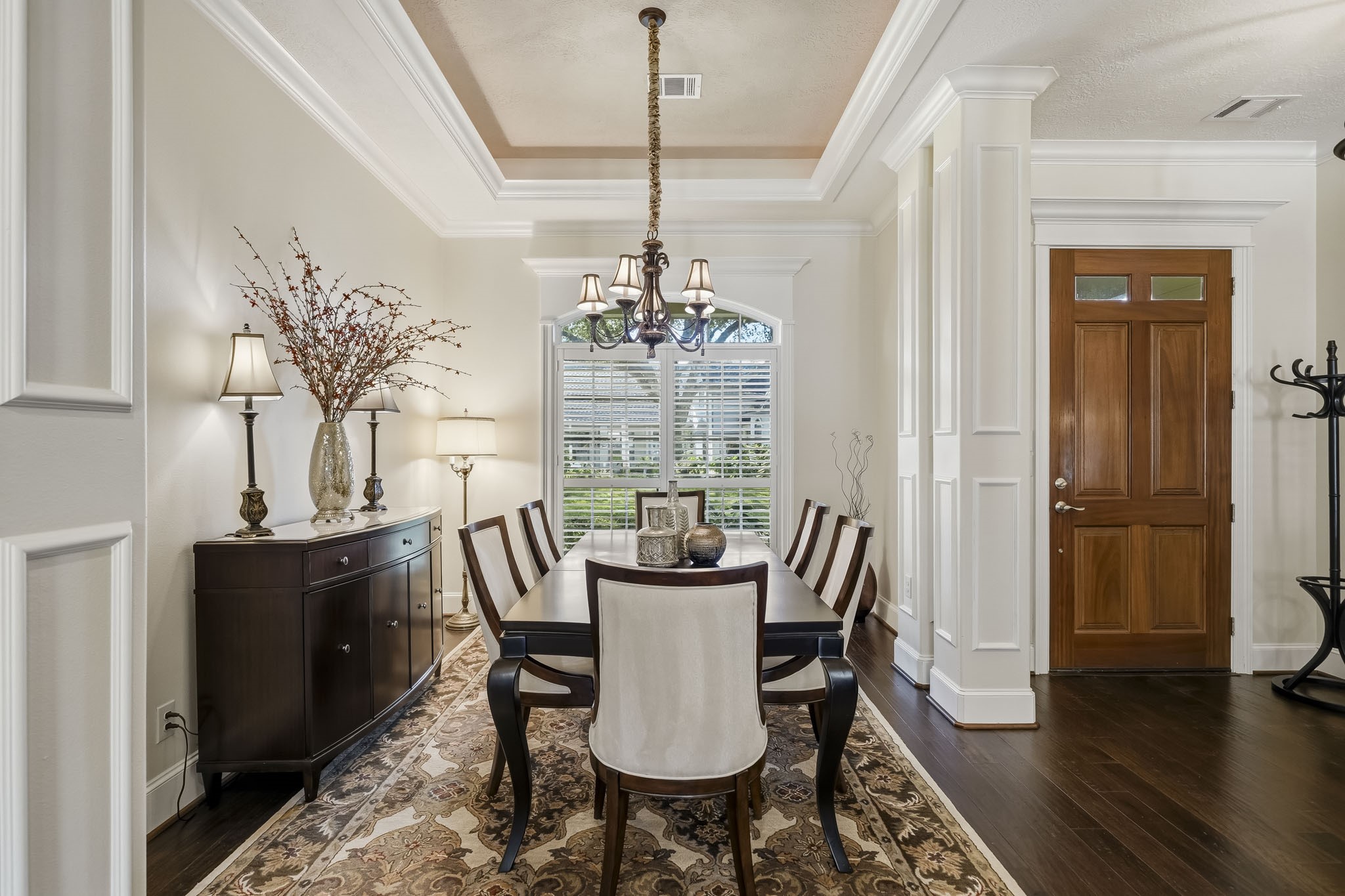 The Dining Room, ideally situated just off the Foyer, is awash in natural light streaming through a stunning arched window. Exquisite double crown molding, a dramatic tray ceiling, and elegantly cased pillars add architectural distinction, creating a refined space that is equally suited for intimate dinners and memorable gatherings. The Dining Room, ideally situated just off the Foyer, is awash in natural light streaming through a stunning arched window. Exquisite double crown molding, a dramatic tray ceiling, and elegantly cased pillars add architectural distinction, creating a refined space that is equally suited for intimate dinners and memorable gatherings.