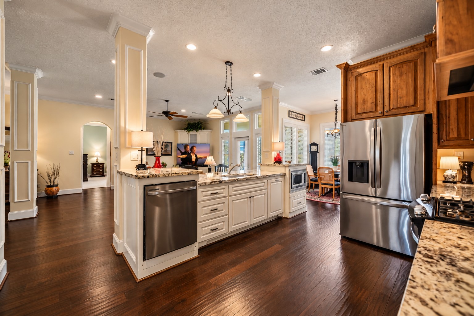 The Kitchen Island serves as both a stunning focal point and a highly functional workspace, framed by beautifully detailed pillars that add architectural character and distinction. An abundance of closed storage provides a place for everything, making it easy to maintain a clean, organized Kitchen. The undermount, single-basin, stainless steel sink is thoughtfully positioned to overlook the Family Room, allowing the home chef to stay connected to family, guests.