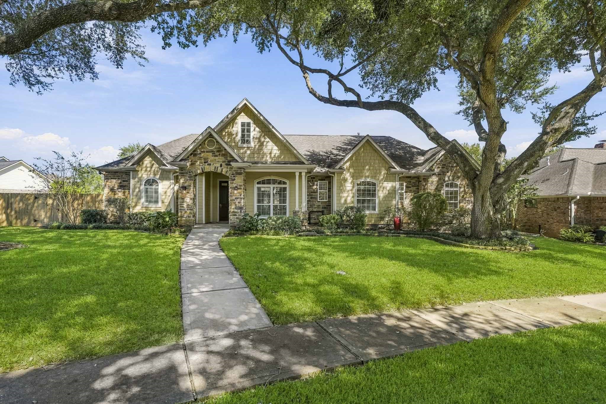 From the moment you arrive, this stylish, single-story home enchants with its picture-perfect curb appeal. A harmonious mix of stone and siding, paired with graceful arched windows and an impressive entry, lends a cozy cottage feel while maintaining a polished, sophisticated presence.