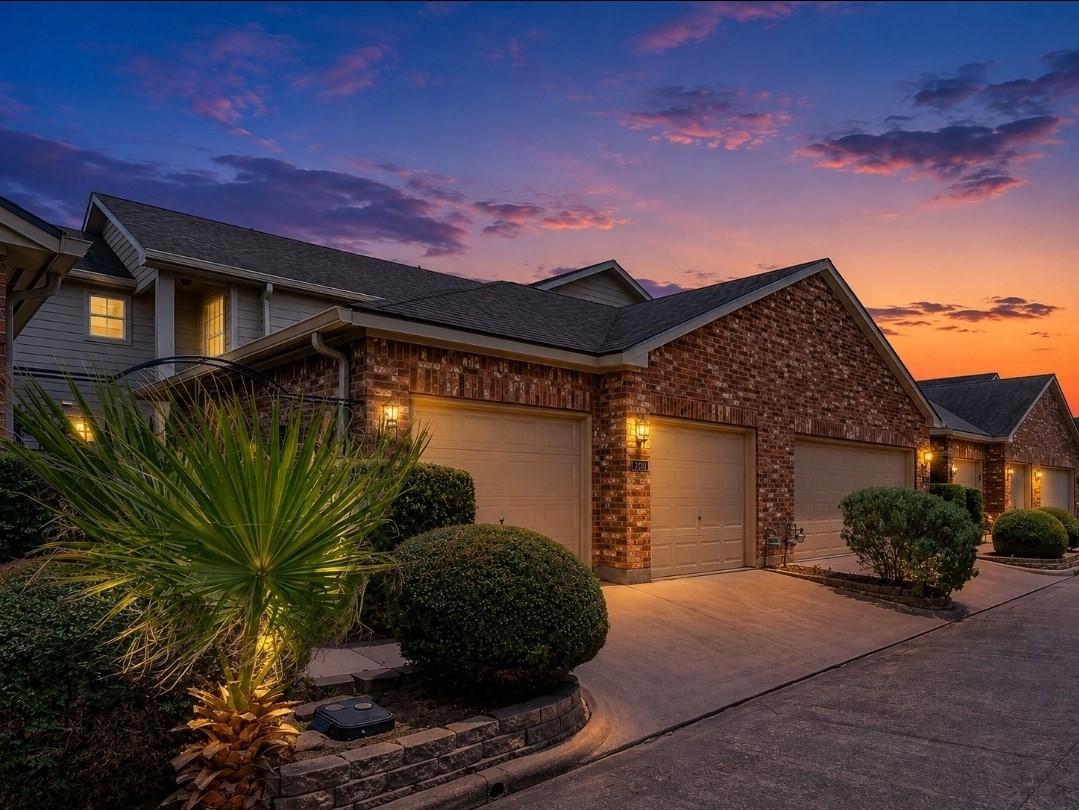 Charming brick townhome glowing at twilight