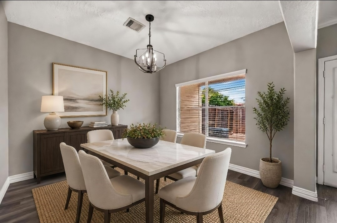 Dining area with a statement chandelier and backyard views  Virtually staged