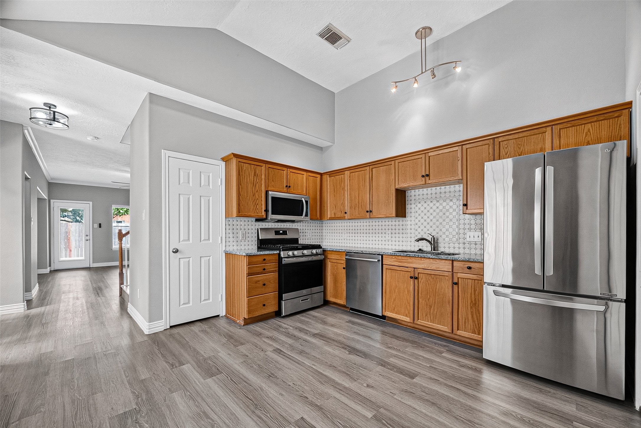 Kitchen features a stainless fridge, range, and ample counters