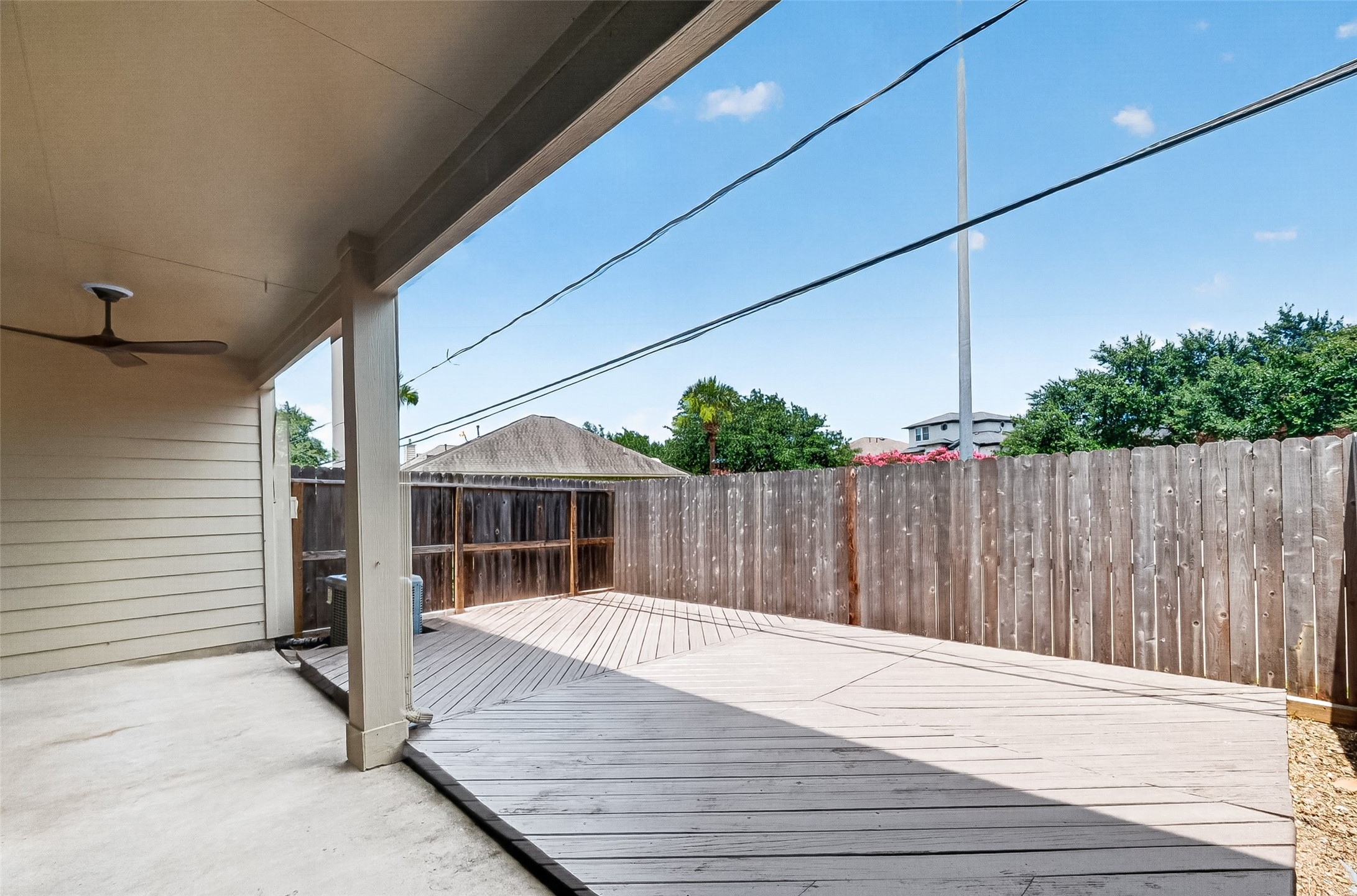 Covered patio overlooks the fenced backyard