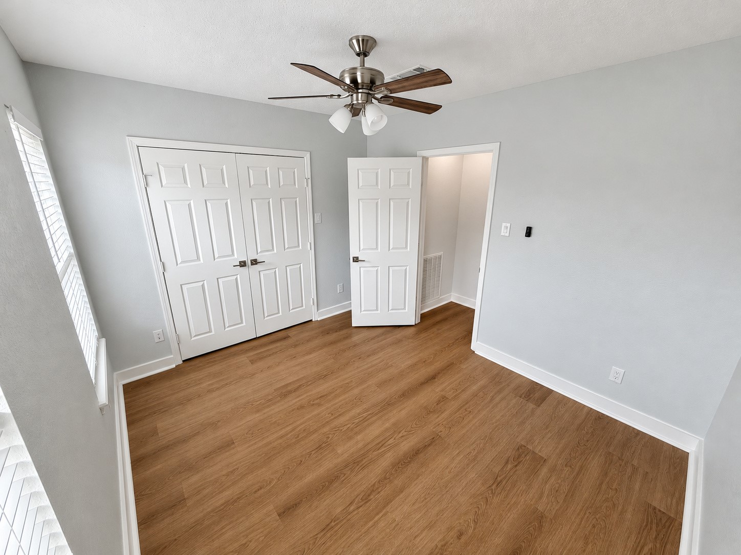 Alternate bedroom view highlighting the closet and hallway access.