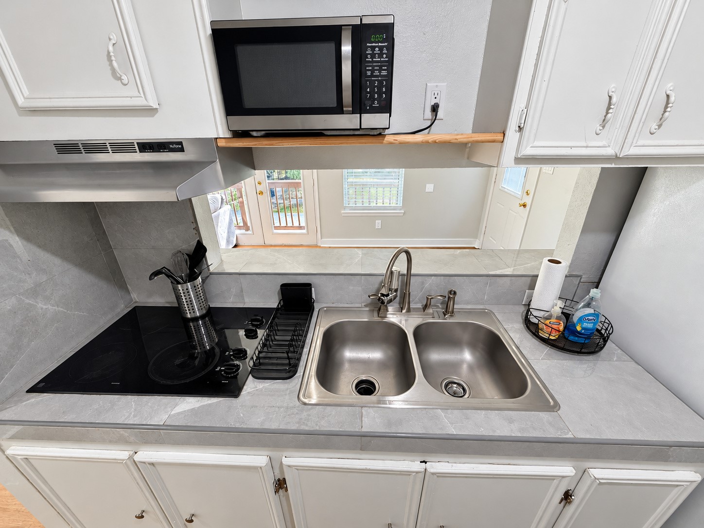 Kitchen with a double-basin sink and pass-through opening to the living area.
