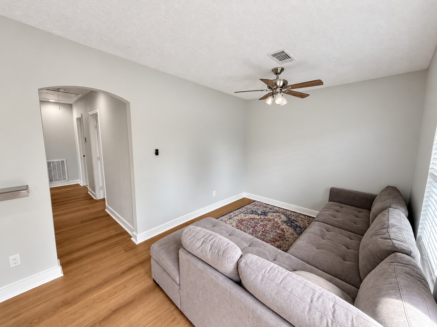 Alternate view of the living area and arched hallway entrance.