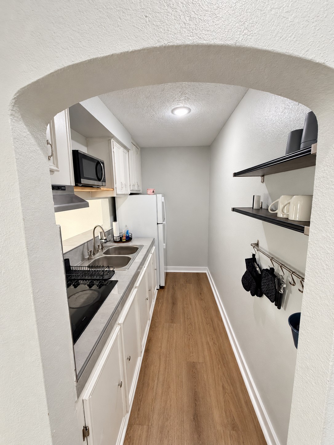 Open shelving and a wall-mounted utensil rail provide convenient kitchen storage.