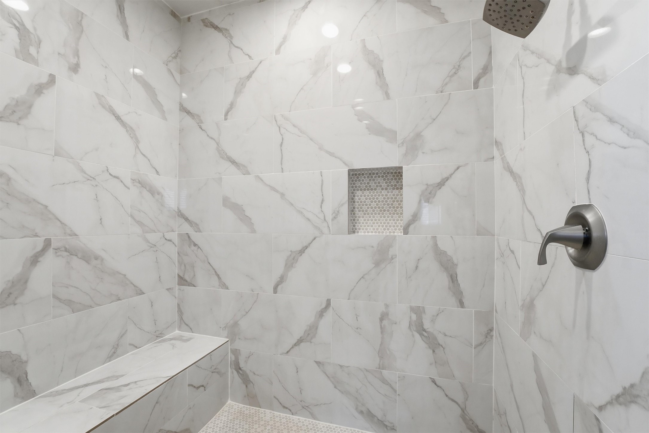 Wrapped in striking tilework, the
walk-in shower brings a polished
designer touch to the primary
bath and adds to the luxurious
feel of this private ensuite.