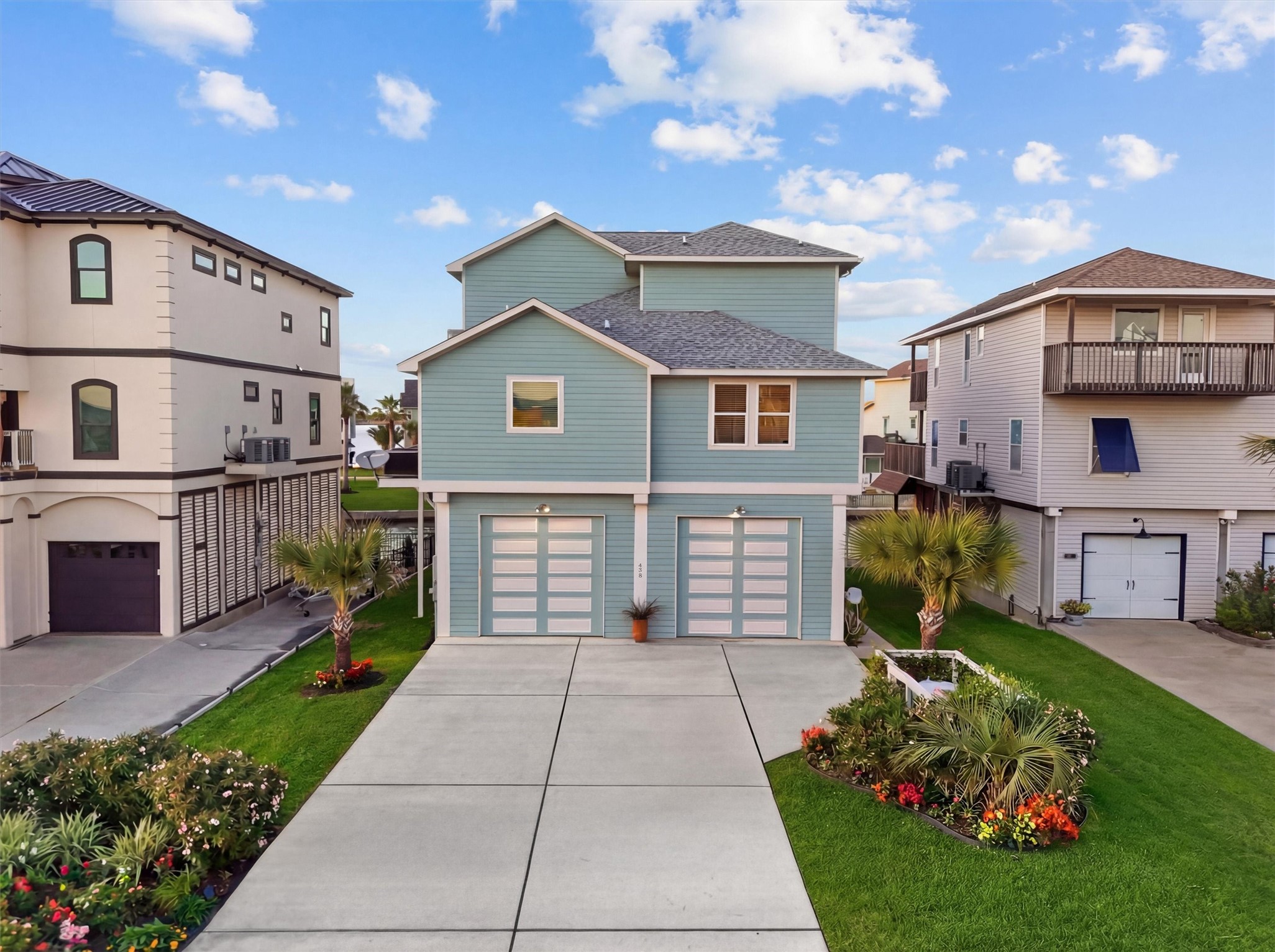 From the moment you arrive, this
home stands out with crisp
coastal architecture, a spacious
driveway, and an oversized
enclosed three-door garage
ready for vehicles, golf carts,
gear, and all the extras that
come with life on the water.