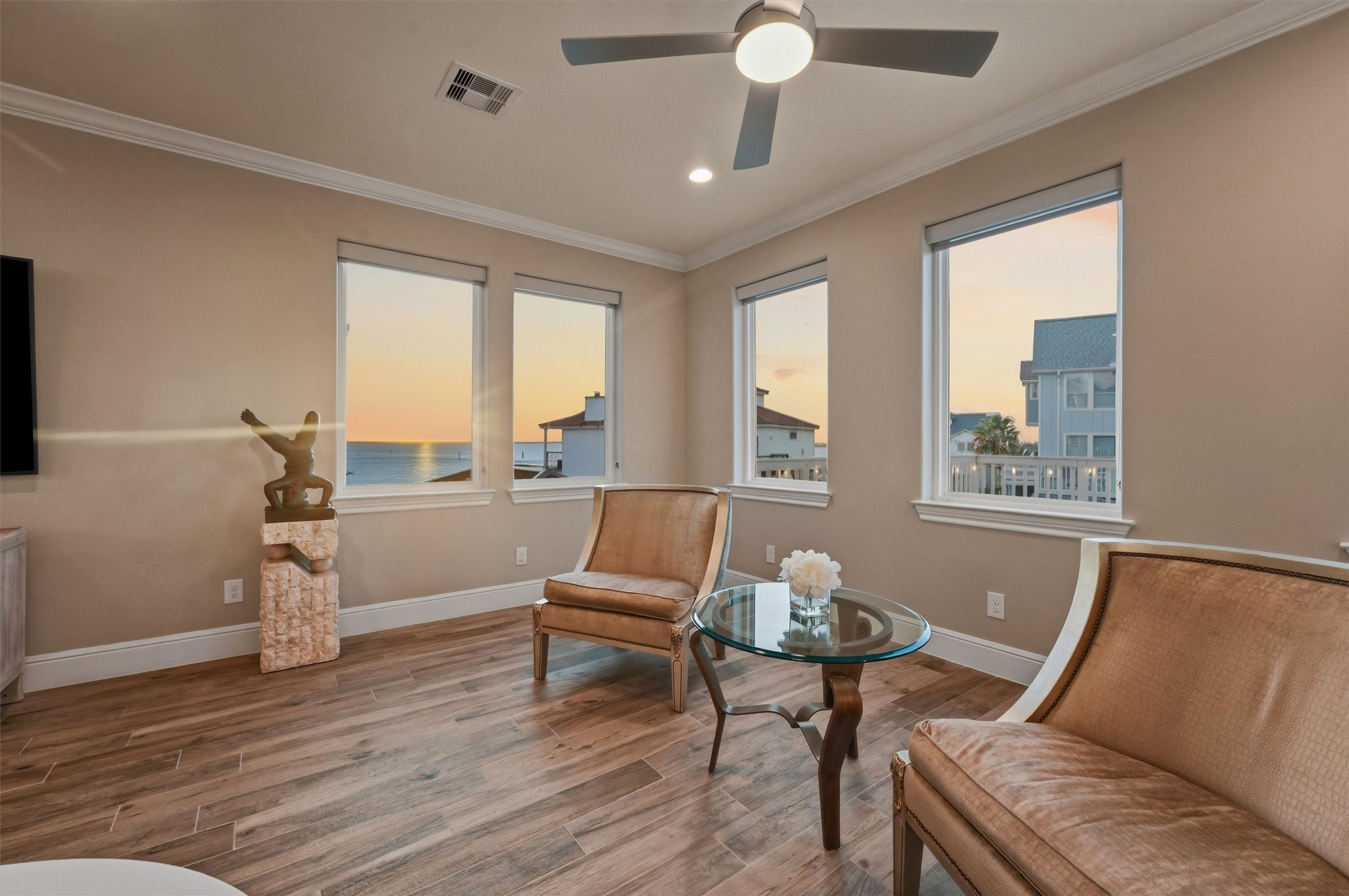 Soft evening light and glowing sunset views give this inviting sitting area a peaceful waterfront ambiance made for quiet conversation and laid-back coastal living.