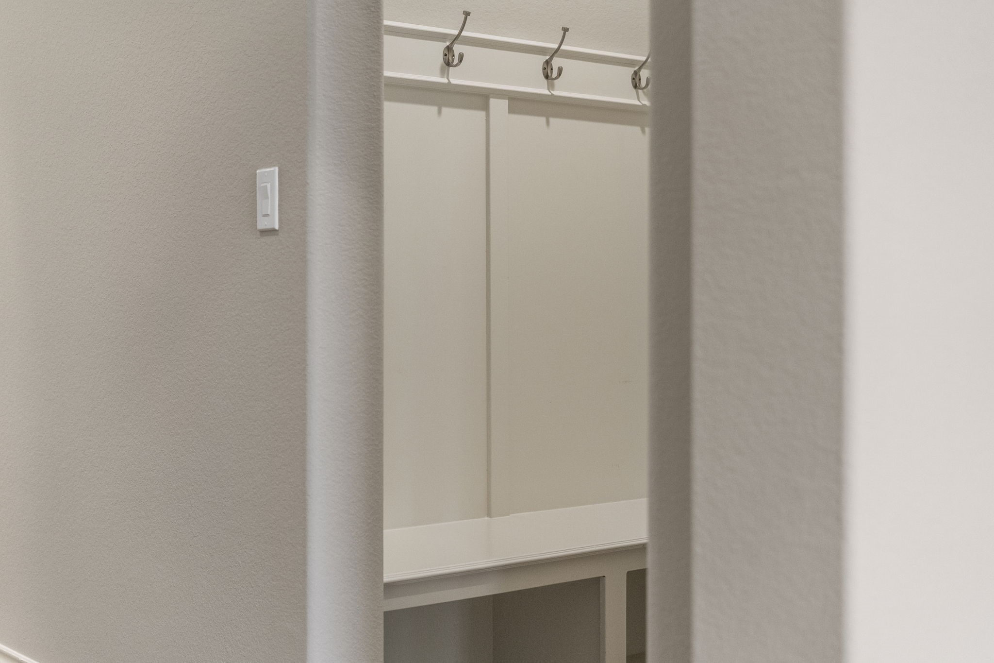 You'll love the built-in bench with storage cubbies below and hooks for coats, located just off the two-car garage.