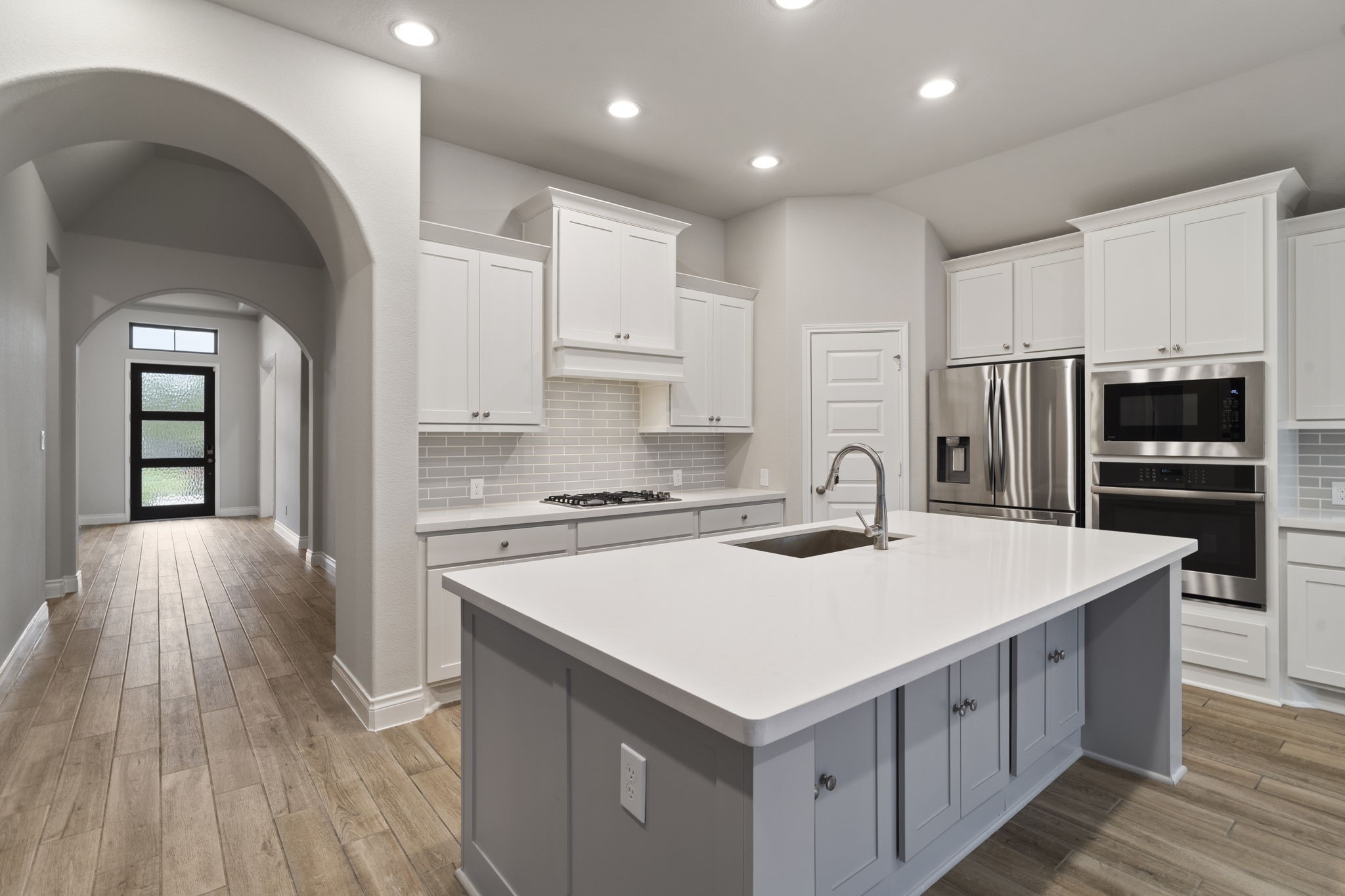 A corner walk-in pantry, generous counter space, and an island with built-in seating make this kitchen both functional and inviting.