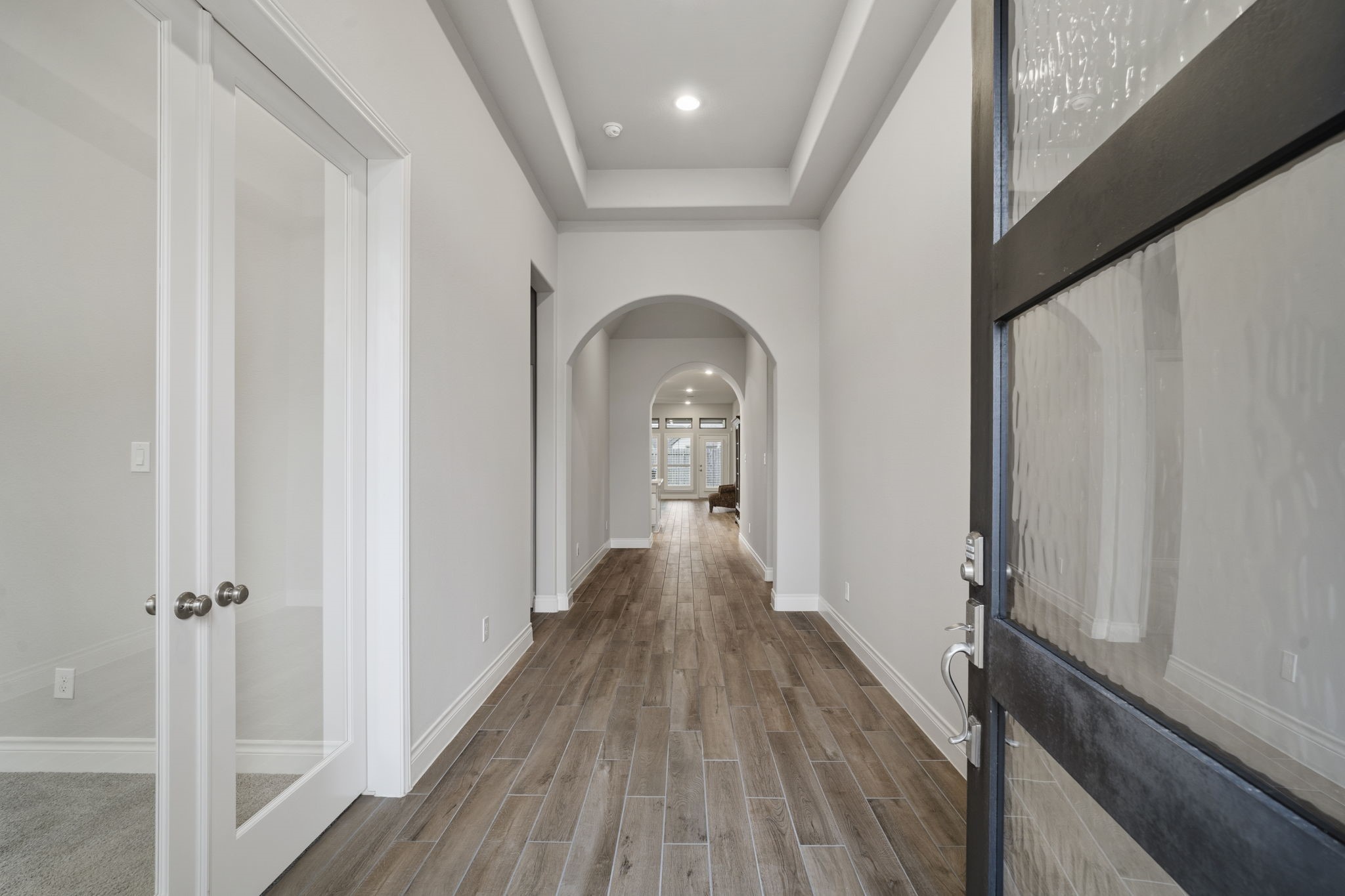 The spacious center hall showcases graceful arched entrances, adding architectural charm.