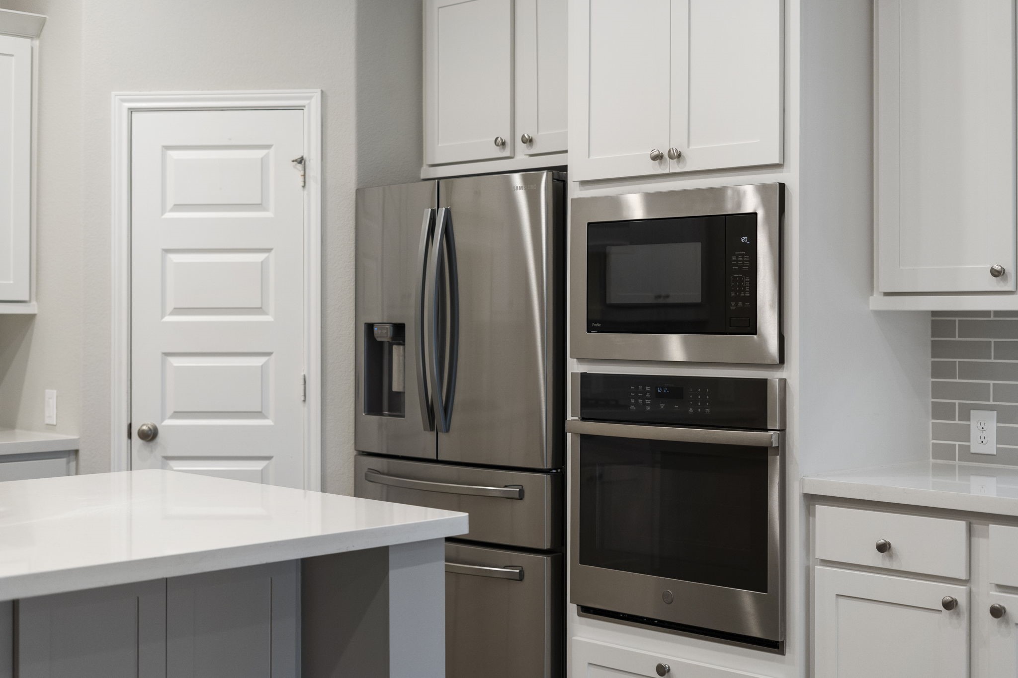 Stainless steel appliances are in excellent condition and include a side-by-side refrigerator with ice and water dispenser, built-in wall oven and microwave, dishwasher, and gas cooktop.
