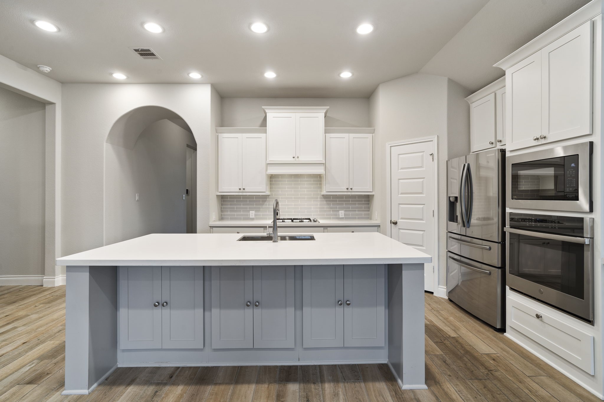 An oversized center island with breakfast bar seating offers the perfect spot for casual dining, along with expansive countertop space and abundant storage.