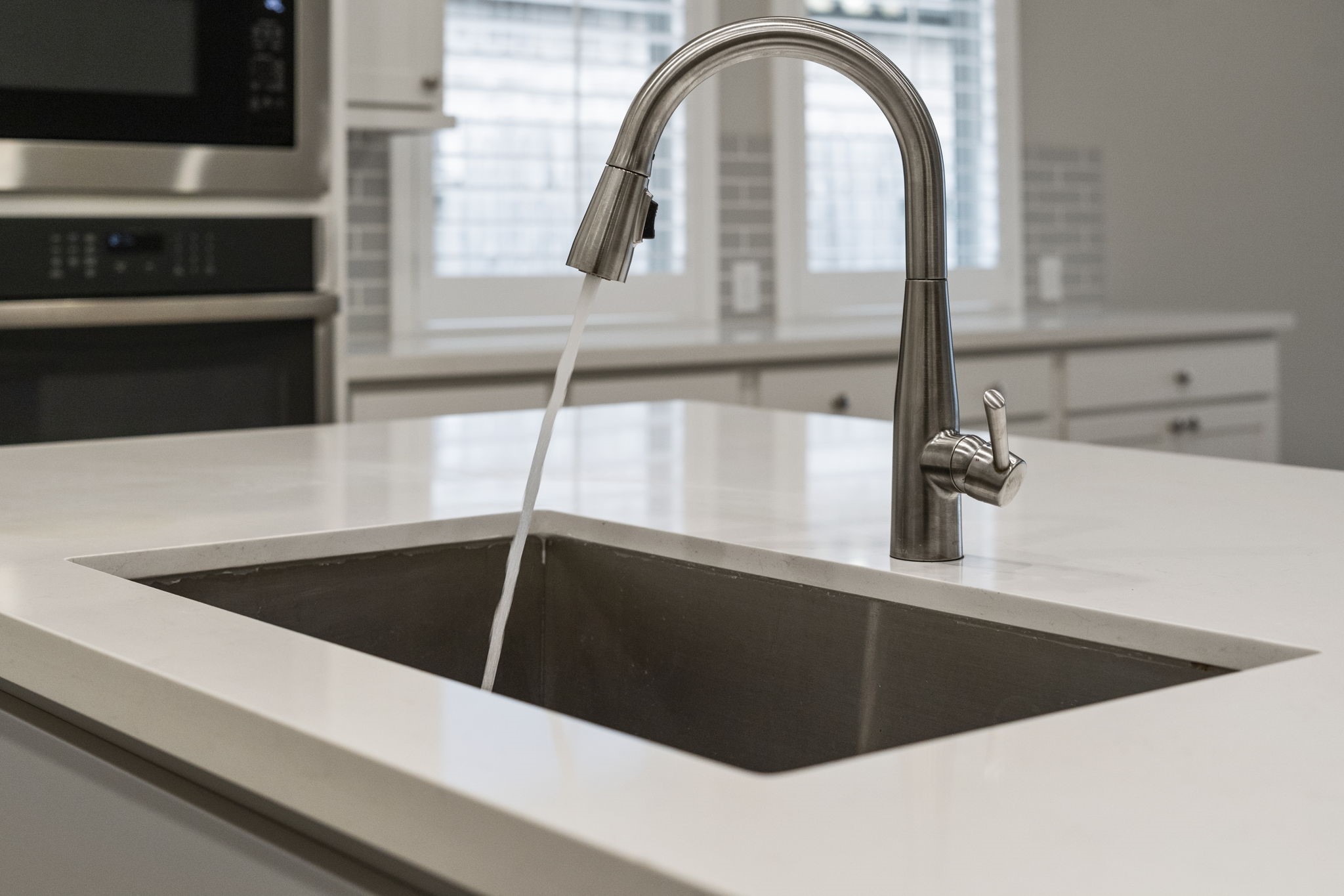 Featuring a deep-basin stainless steel undermount sink paired with a sleek gooseneck faucet with a handy pull-down sprayer.