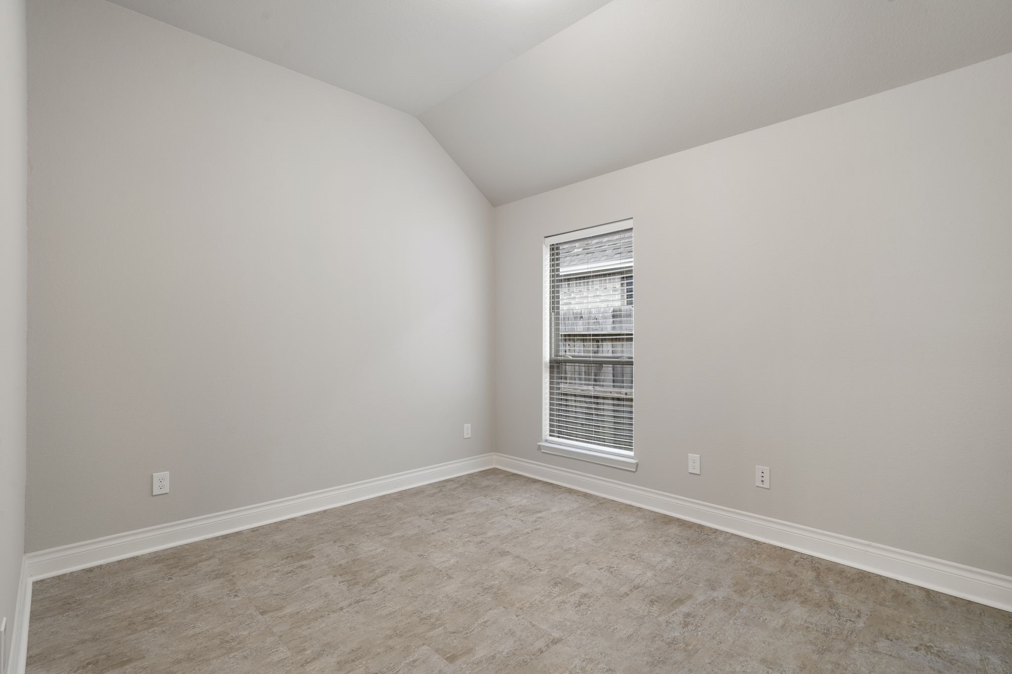 Travertine tile flooring makes this versatile room ideal for a home gym, hobby space, or additional bedroom.