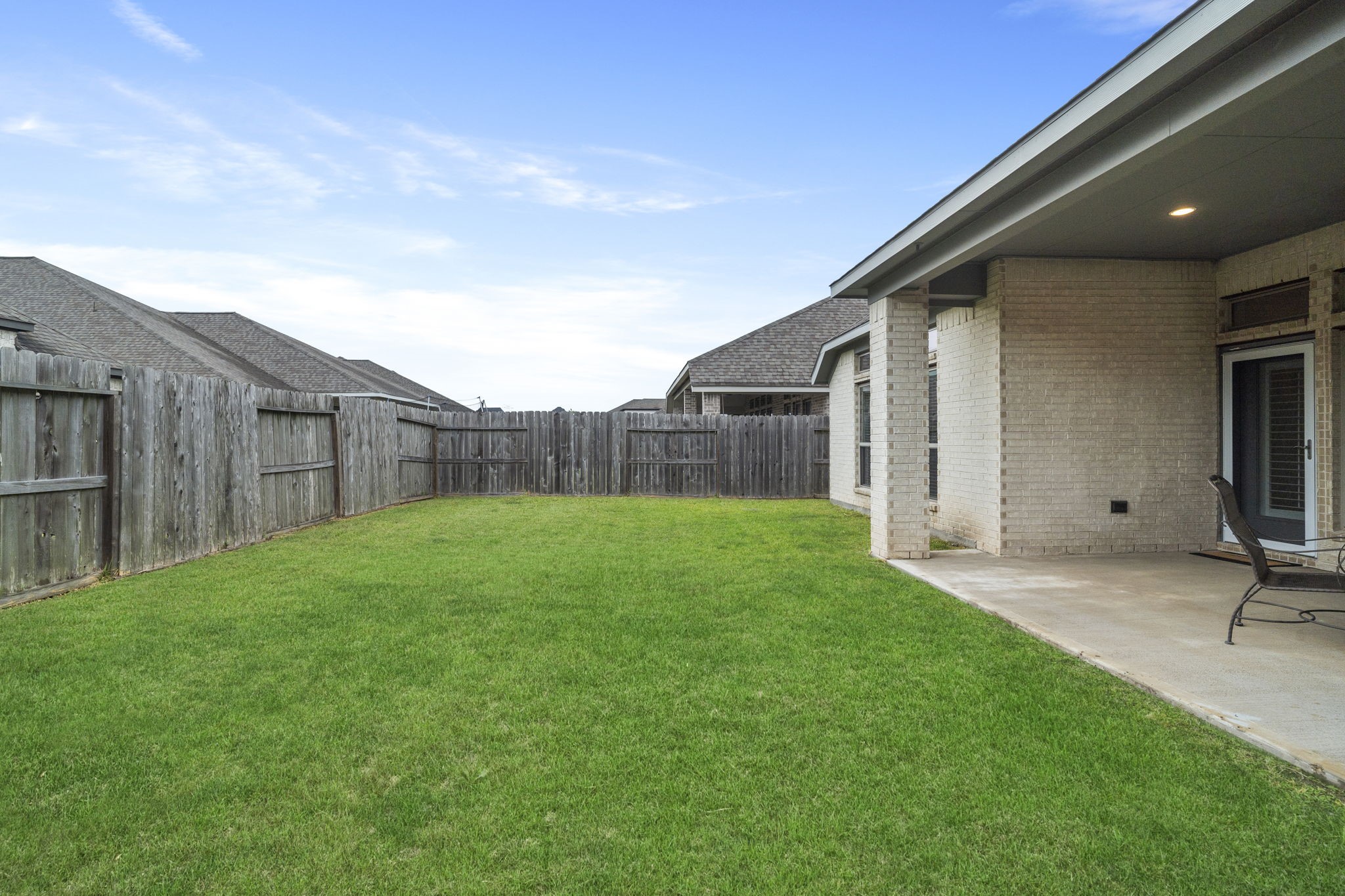 A spacious grassy yard offers plenty of room for kids to play, pets to roam, and outdoor activities.