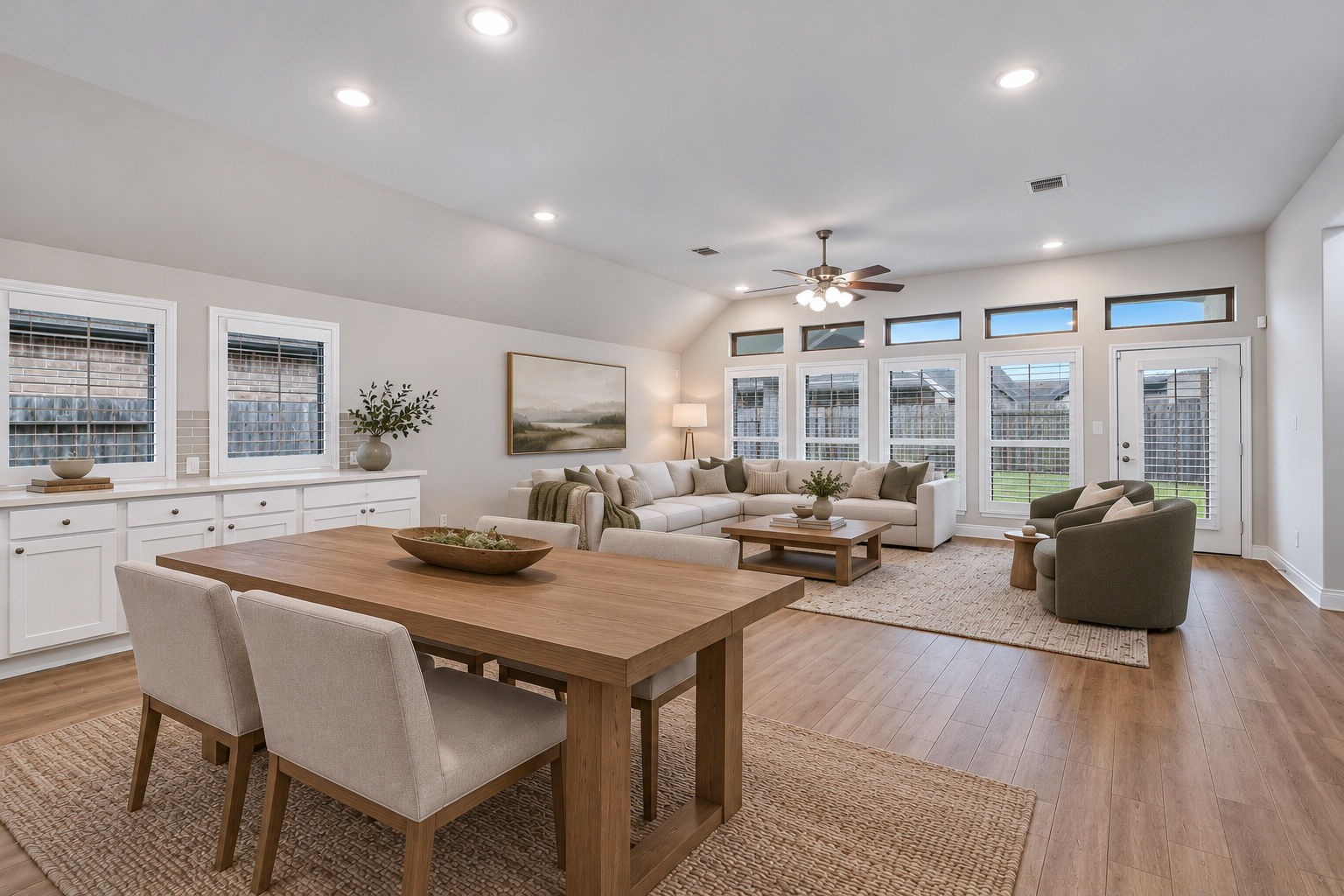 A wall of windows fills the family room with natural light. Digitally staged.