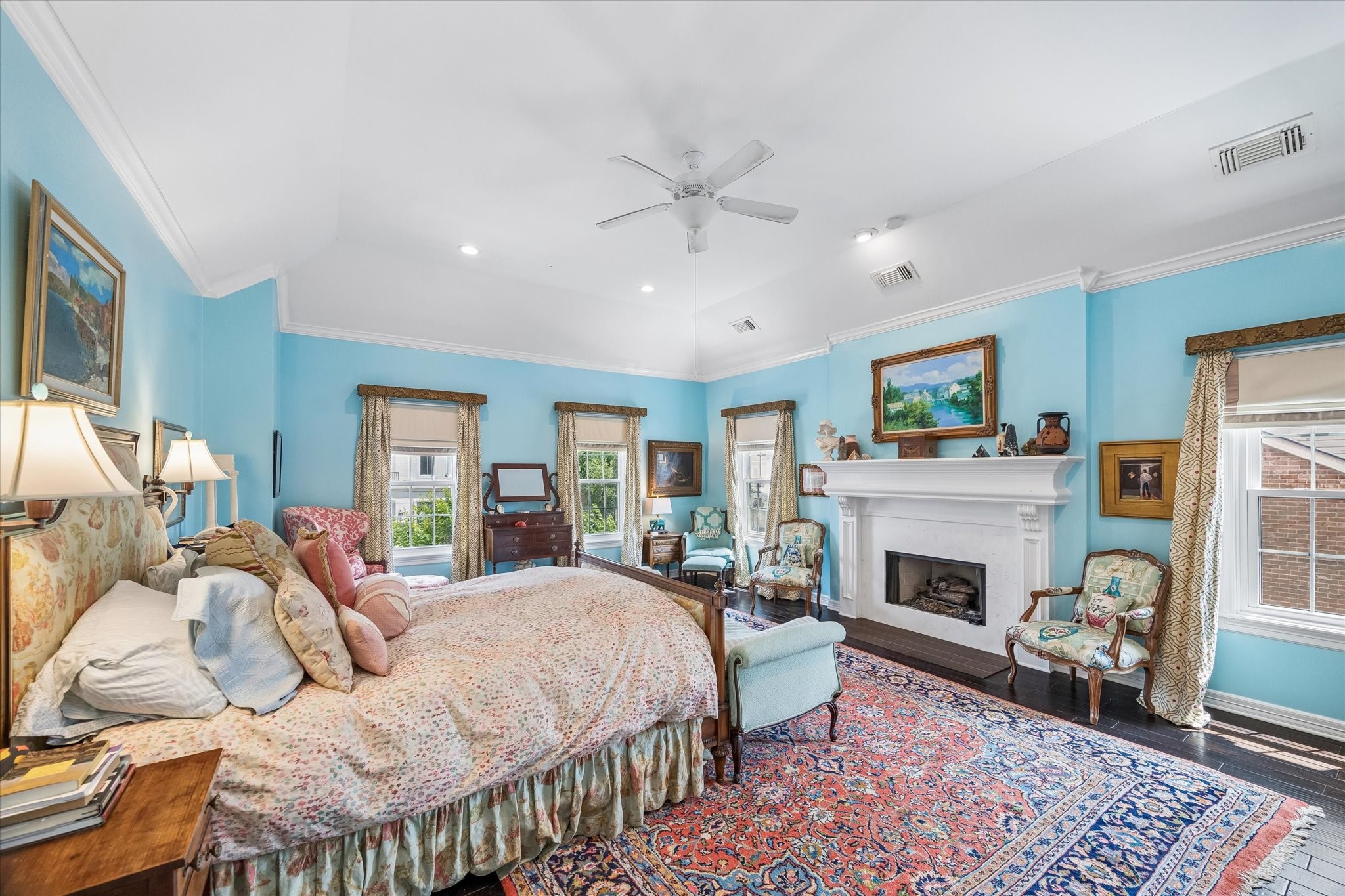 The primary bedroom is a serene retreat. A large fireplace adds an extra layer of comfort and walls of windows bring in natural light!