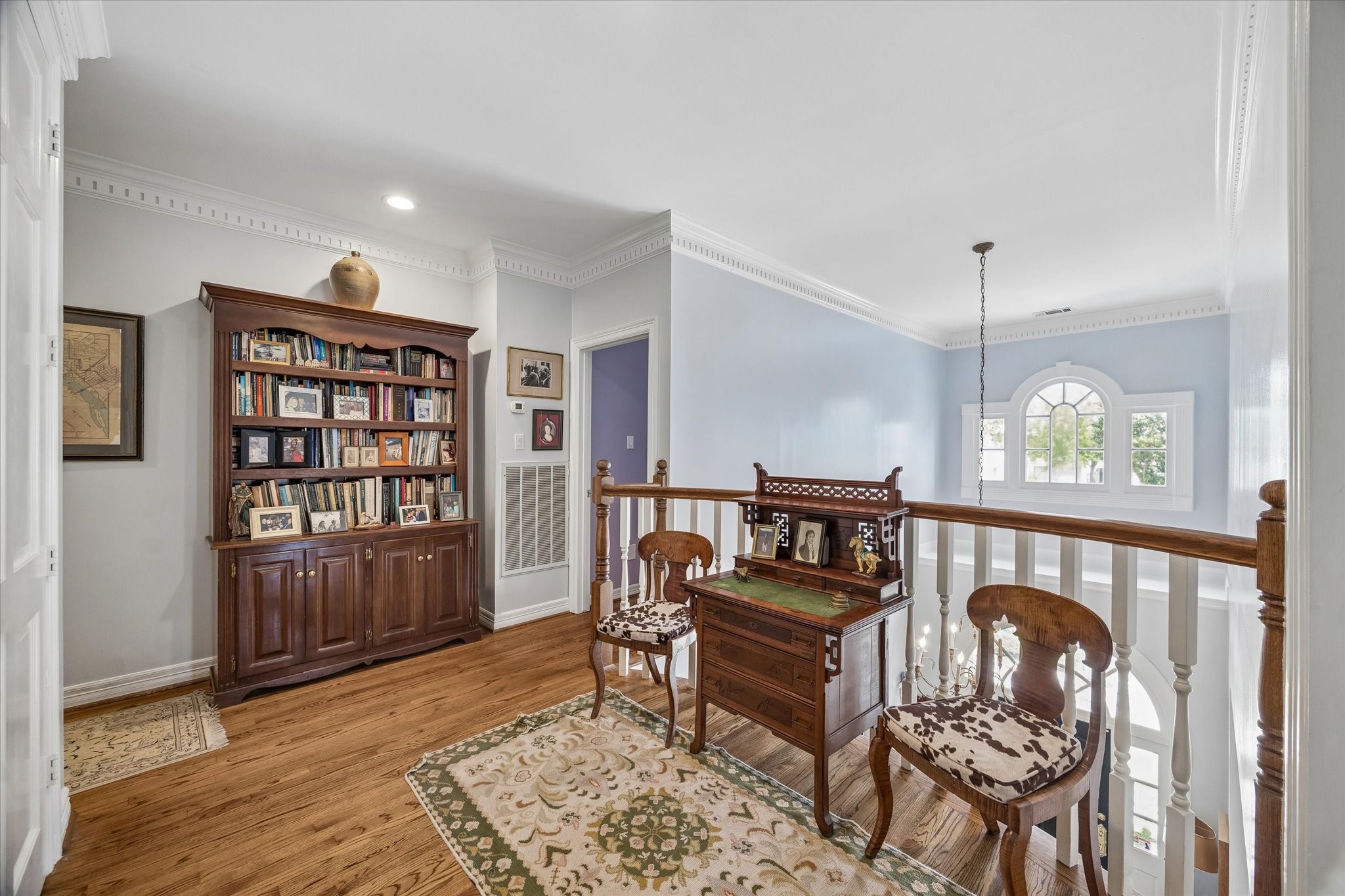 The second floor landing overlooks the first floor entryway, bringing in tons of natural light. Dental crown molding and hardwood floors continue throughout the second floor.