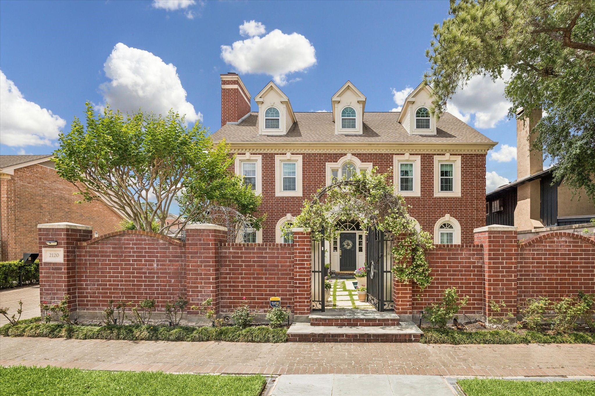 This stunning red brick home has gorgeous curb appeal. The gated front allows for privacy from the street.