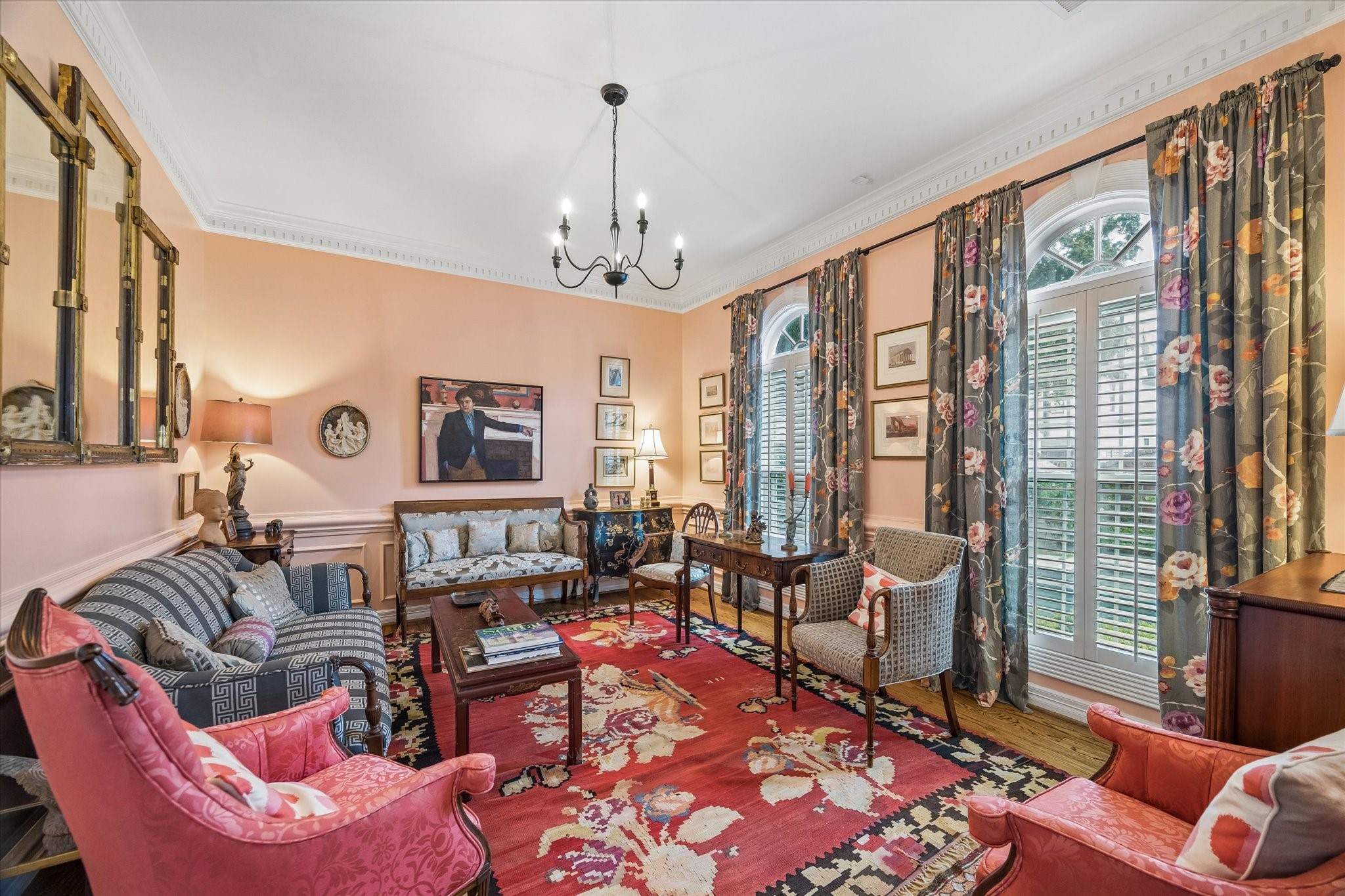 To the right of the entry is the formal living room. Hardwood floors, dental molding, and windows overlooking the pool accentuate the space. The painted wainscoting adds an elegant touch.