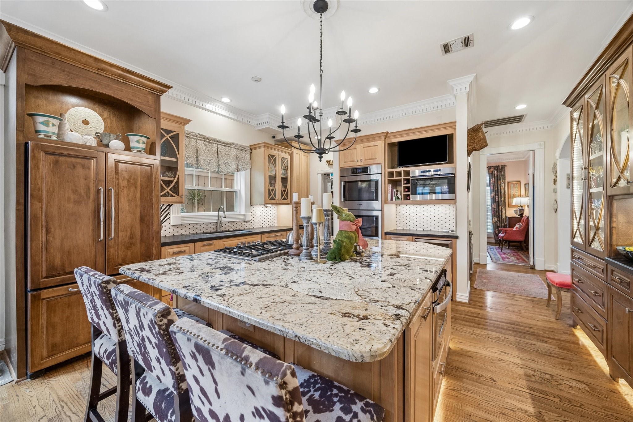 Kitchen also features two Bosch convection ovens, Bosch warming drawer, Wolf steam convection oven, and a Danby wine refrigerator. To the right is a gorgeous armoire piece that allows for plenty of storage. Island and armoire both feature lighting underneath!