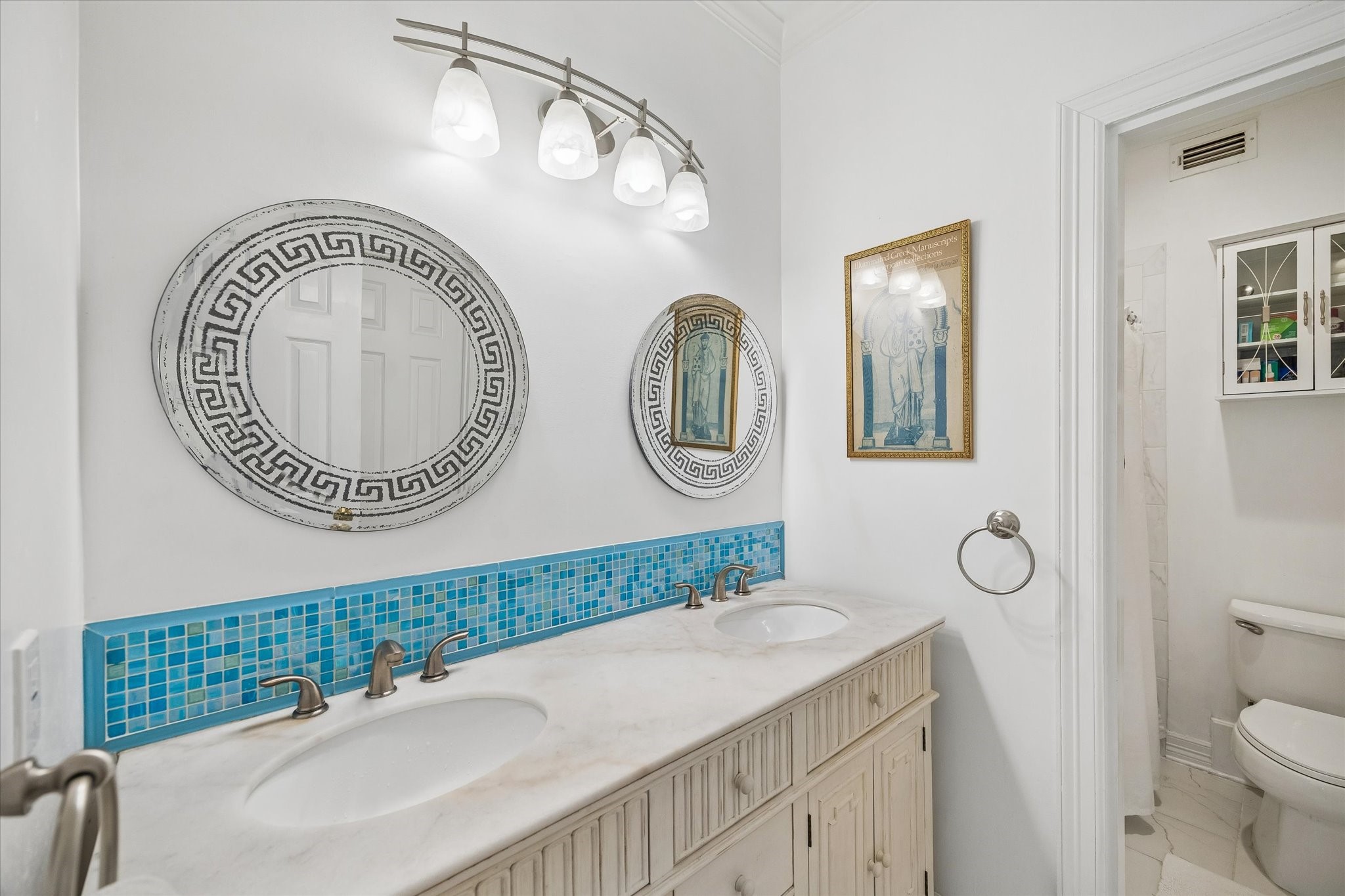 This secondary bathroom features a shower/bathtub, dual sinks, and plenty of under sink storage.
