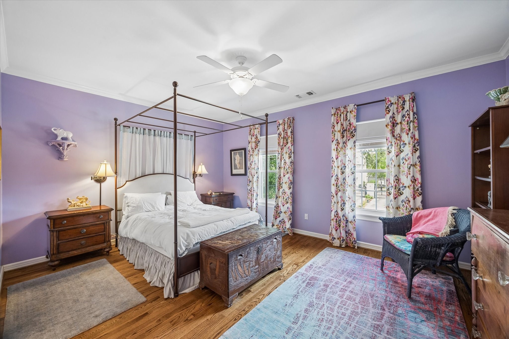 The front secondary bedroom features beautiful lavender walls, hardwood floors, crown molding, and an en-suite bath with a walk-in closet.