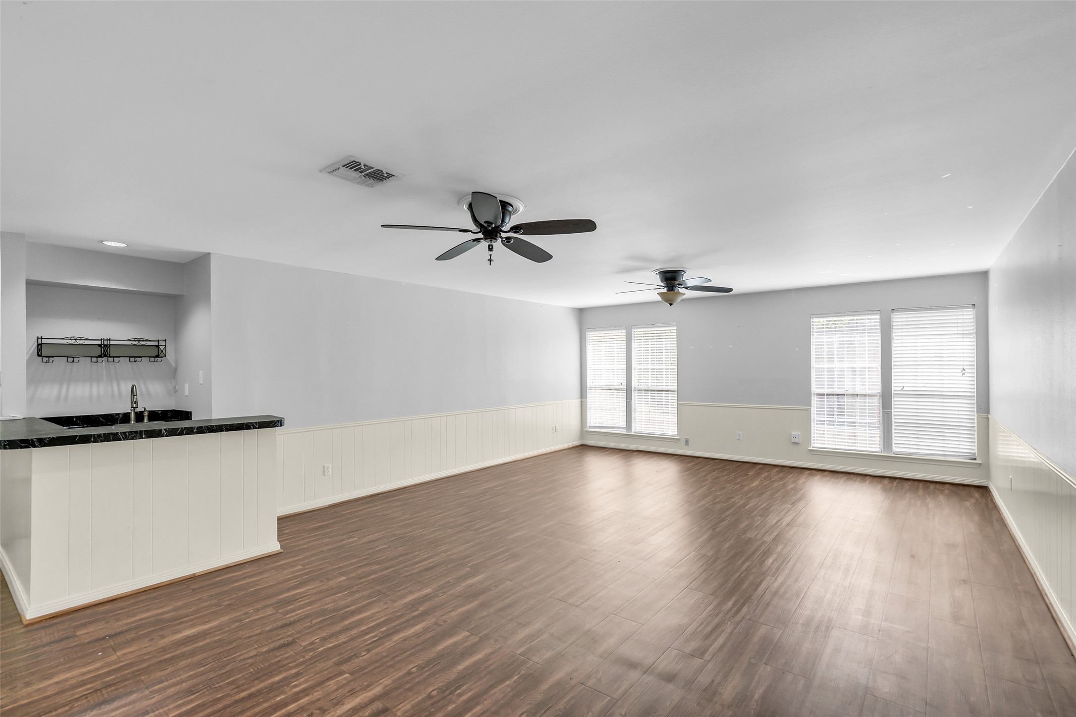 Spacious flex room on the second floor overlooking the backyard, suitable for a game room or sitting area, and equipped with a built-in counter and sink for added convenience.
