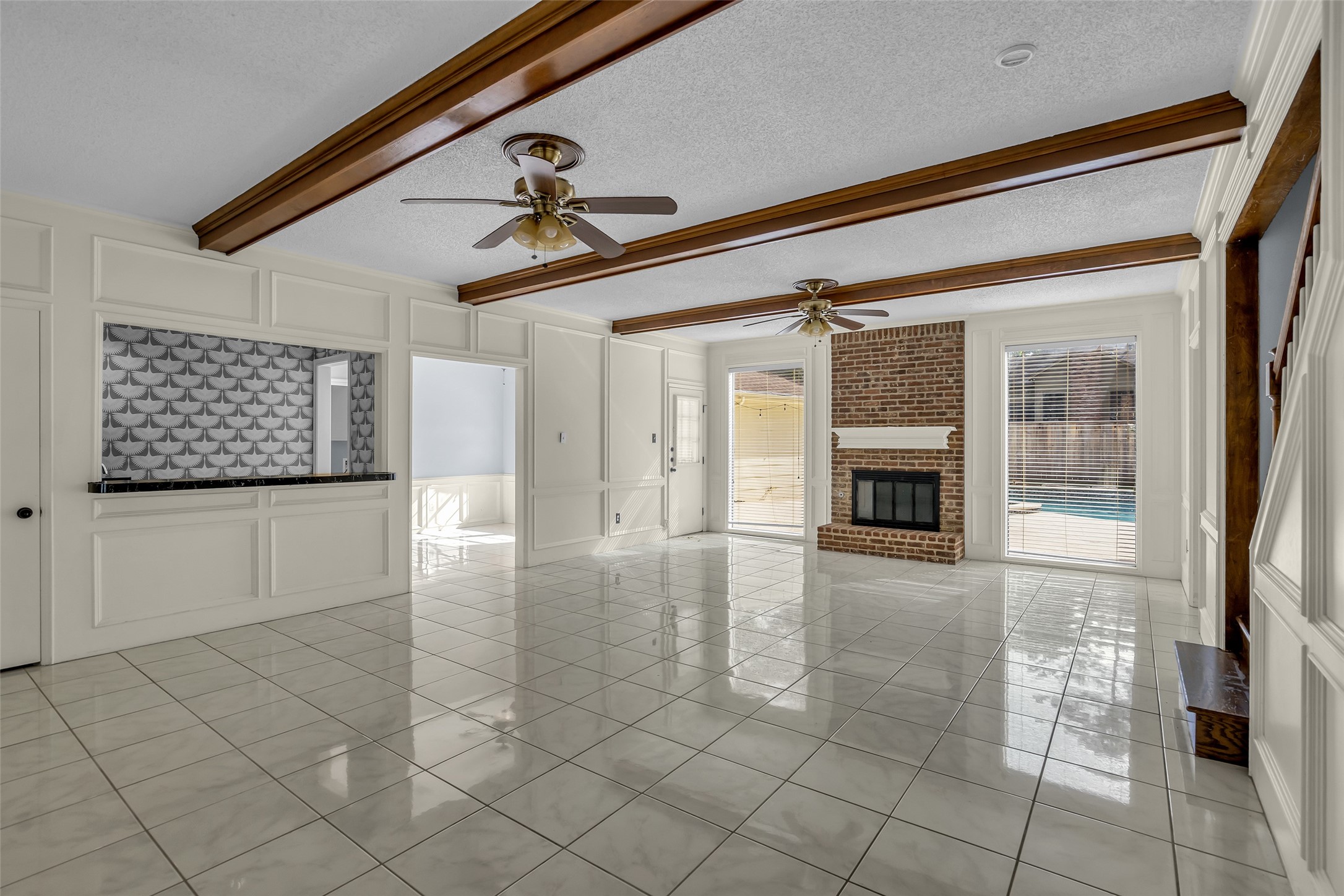 A wet bar is conveniently located to the side, and windows along the back overlook the pool, bringing in plenty of natural light.