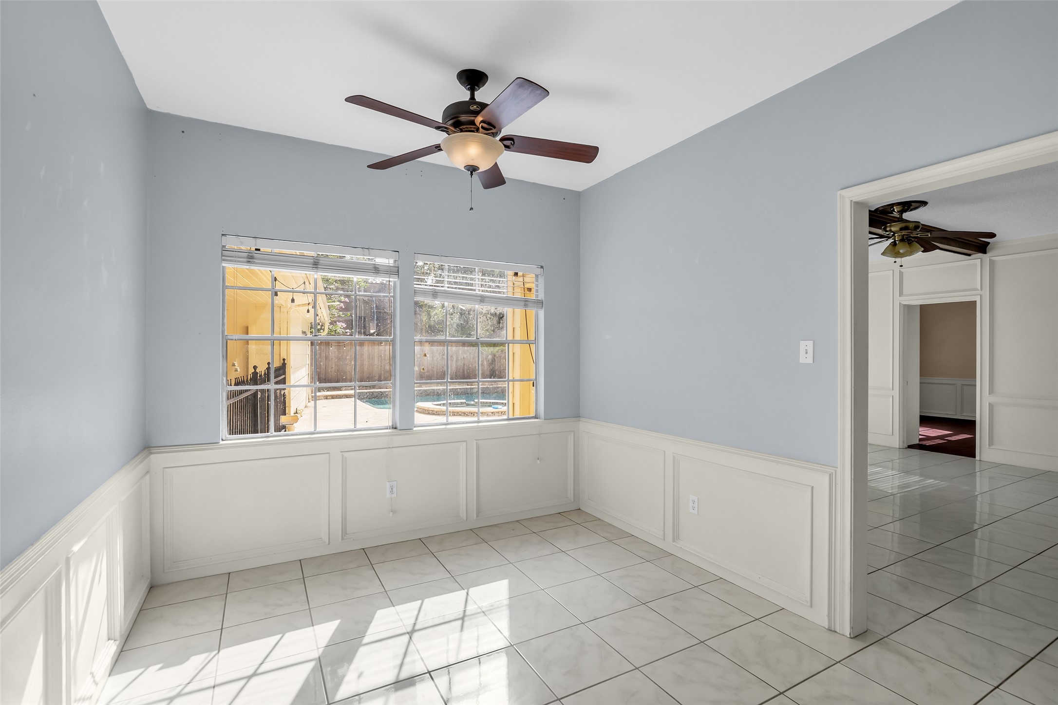 The breakfast nook is bright and welcoming, with large windows that bring in plenty of natural light while overlooking the backyard pool.