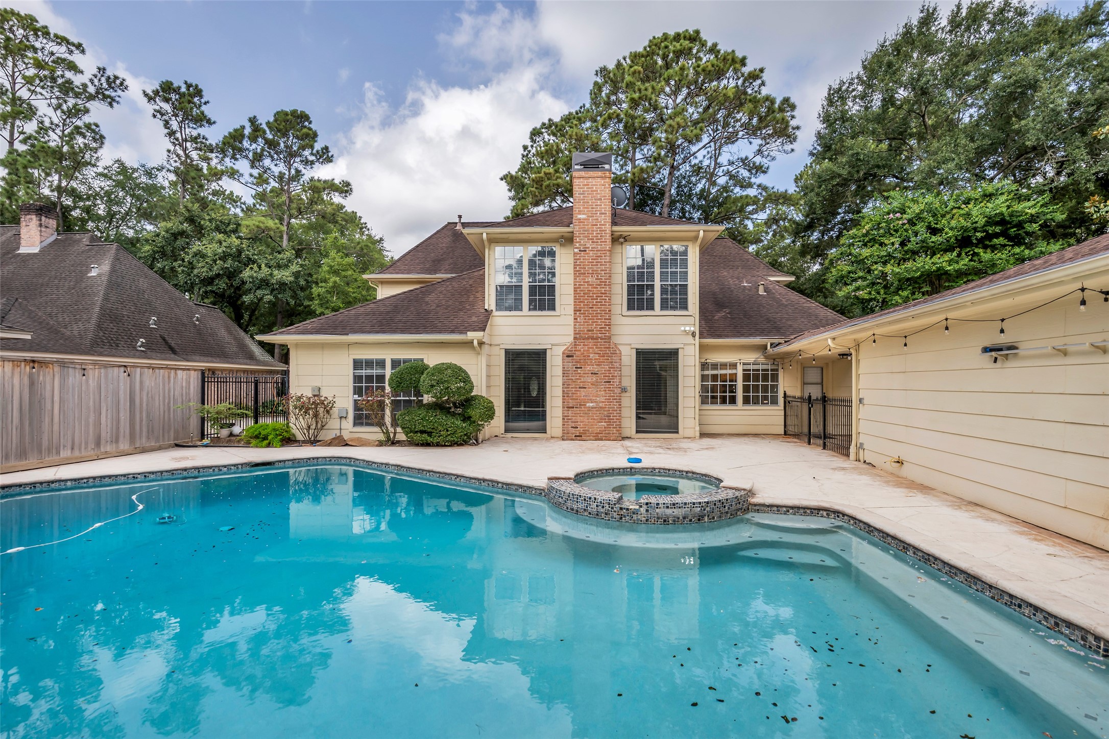 Features an in-ground pool with an attached hot tub, creating a versatile space for outdoor enjoyment.