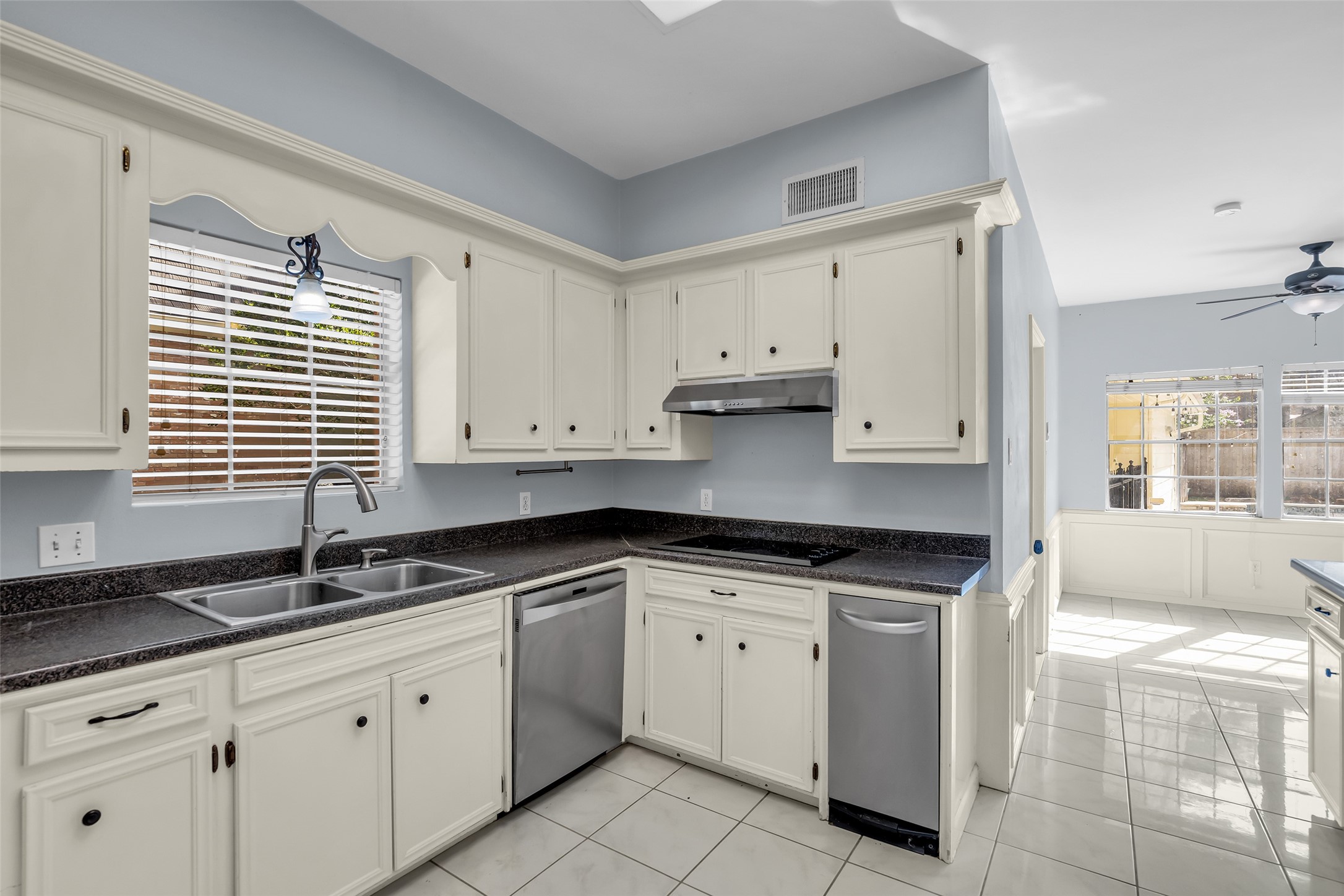 The kitchen is equipped with stainless steel appliances, including a dishwasher, disposal, microwave, double oven, electric cooktop, and compactor.