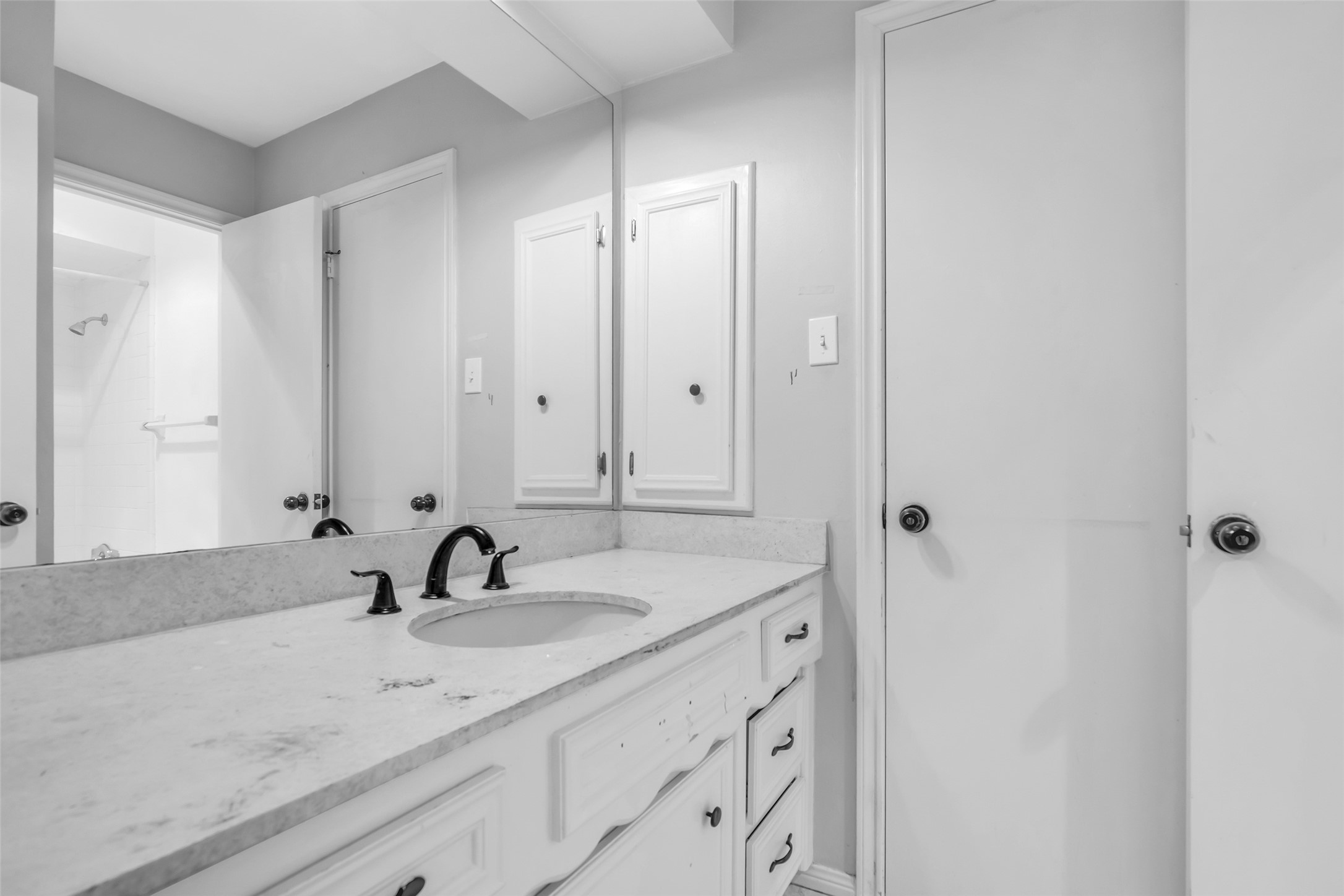 Inside the en suite bathroom, a large vanity and modern fixtures provide a clean, functional space for daily use.