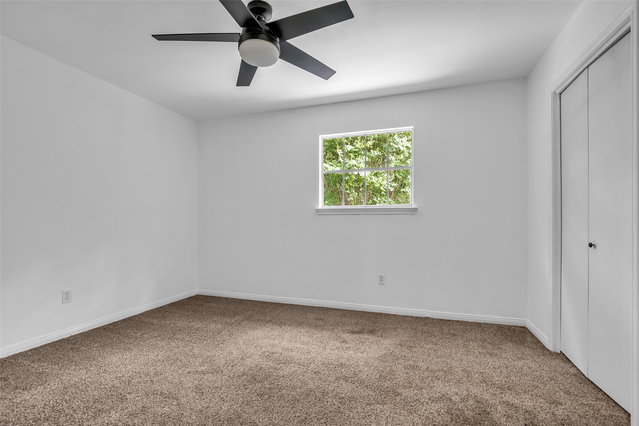 Another bedroom on the second floor with a small window facing the side of the home, featuring an en suite bathroom and a built-in wardrobe for convenient storage.