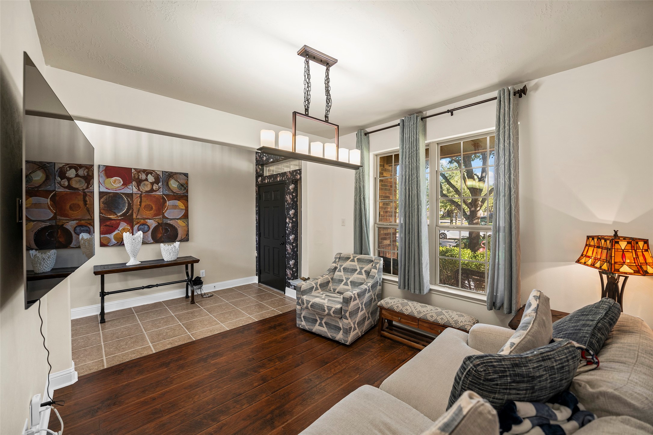 This versatile space can serve as a secondary living room, a formal dining room, or a dedicated home office. Note the beautiful light fixture and the wood floors.