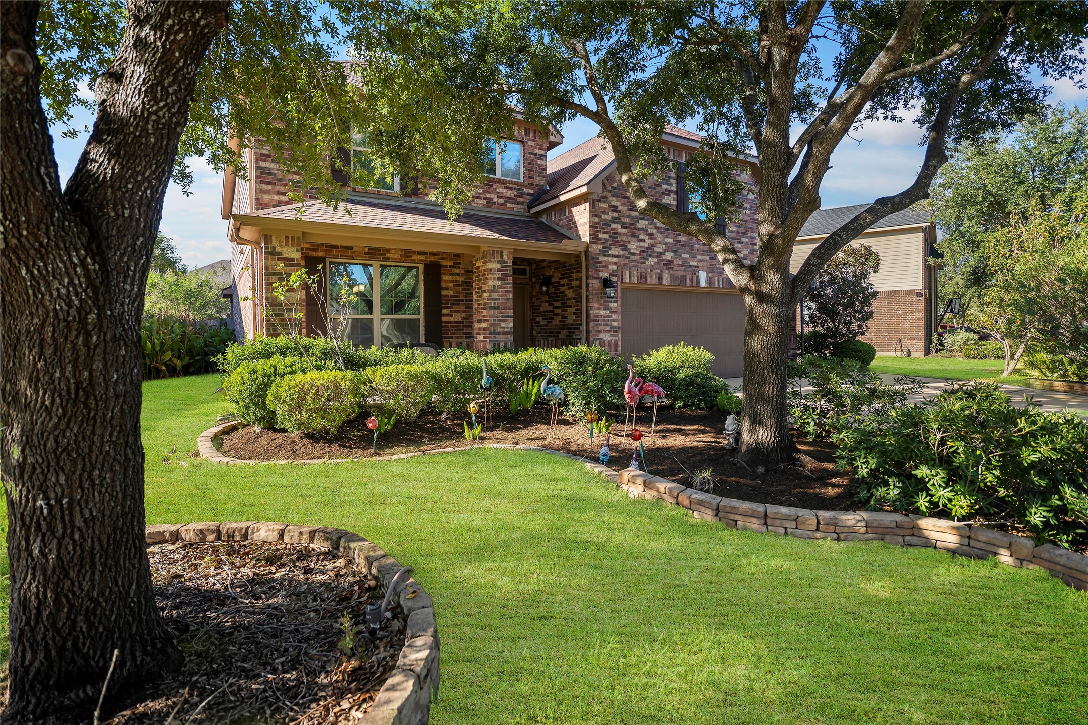 Front yard featuring mature trees and beautiful landscaping.