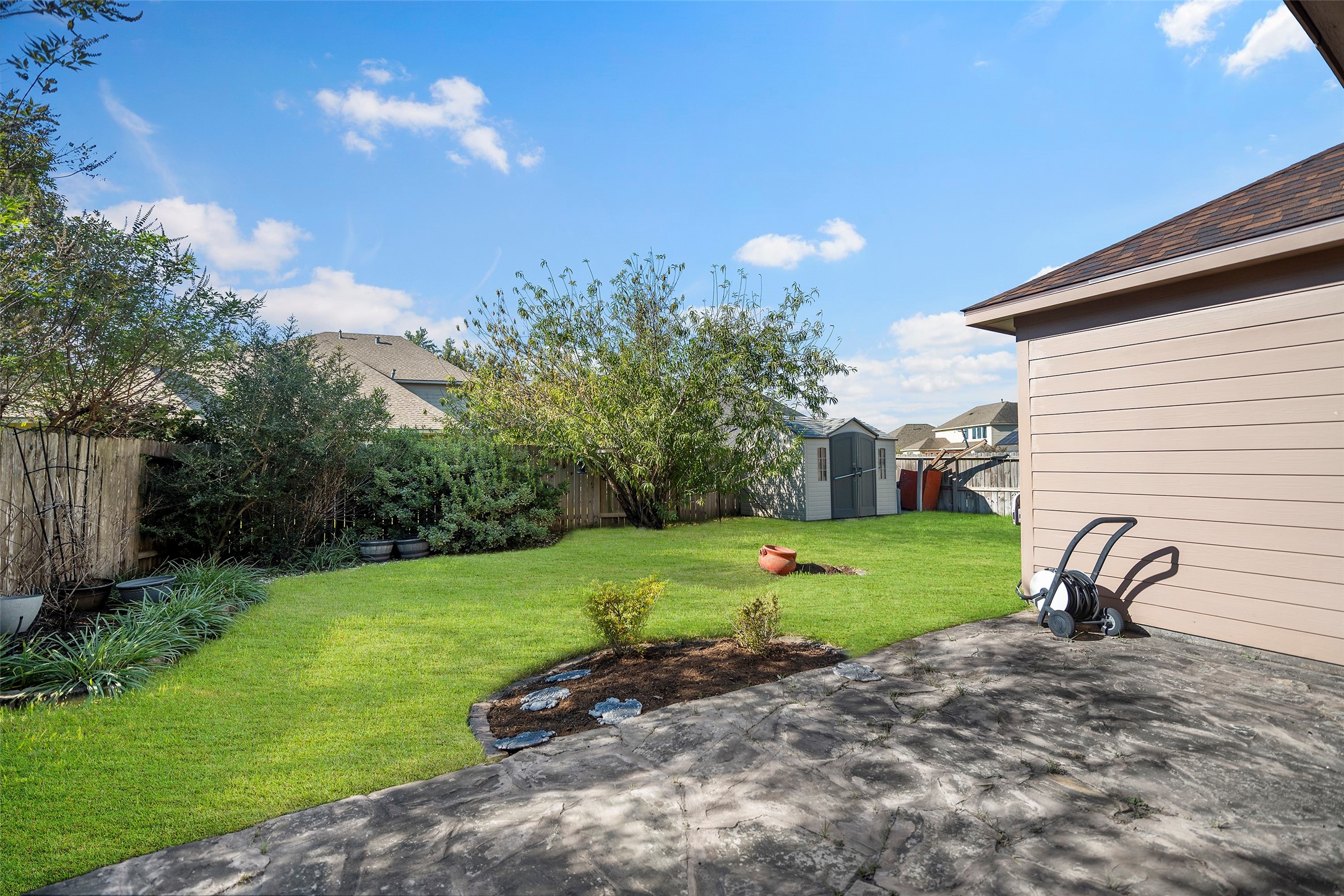 This spacious backyard features a large patio and it's fully fenced. Note: The grass in this photo has been virtually enhanced to demonstrate the property's full potential.