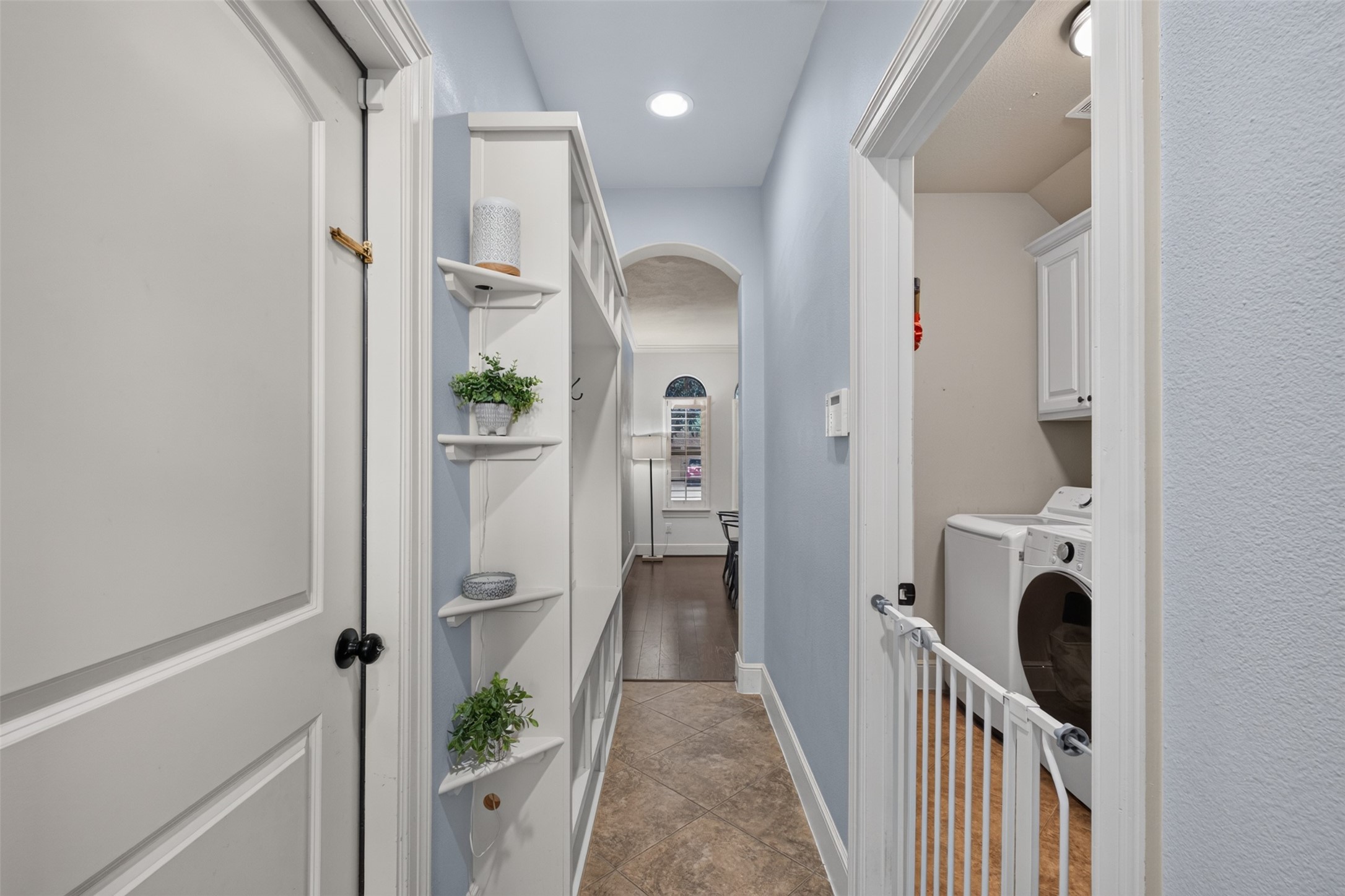 Hallway leading from the kitchen to the dining room includes built in coat and storage rack.