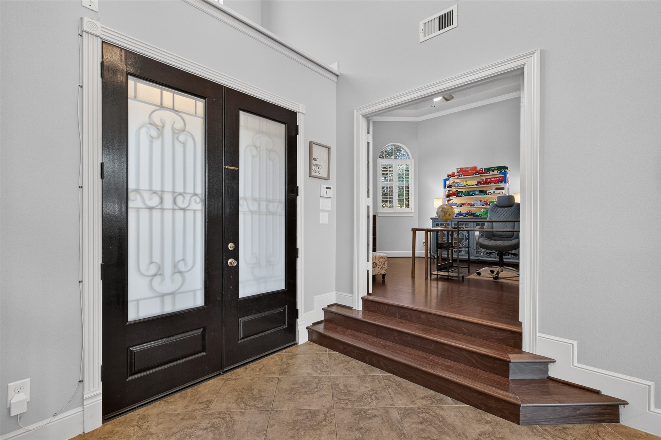 Steps lead to the glass French doors to the study/home office. Fabulous space with plenty of privacy for home working, with wood floors and crown molding
