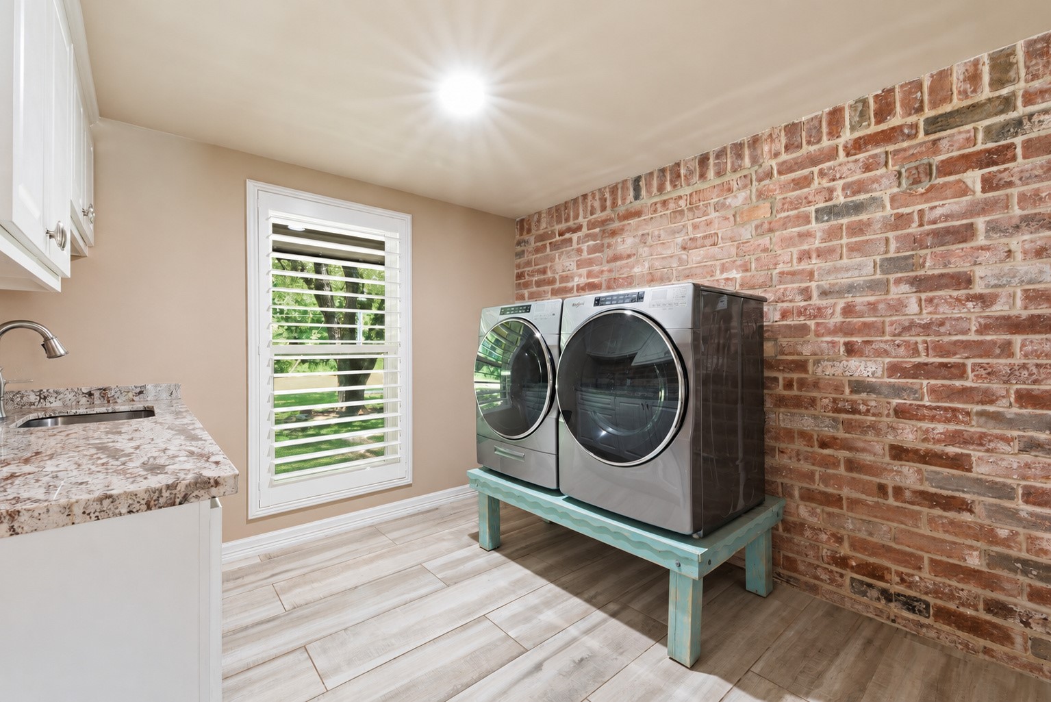 Laundry room with brick accent wall