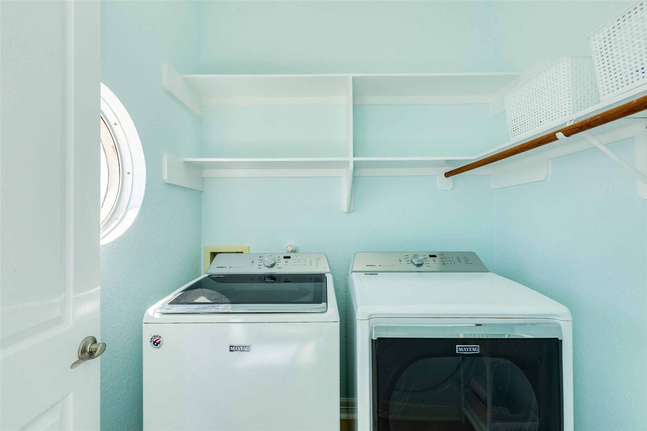 Utility room off the kitchen has built-in cabinets and shelves