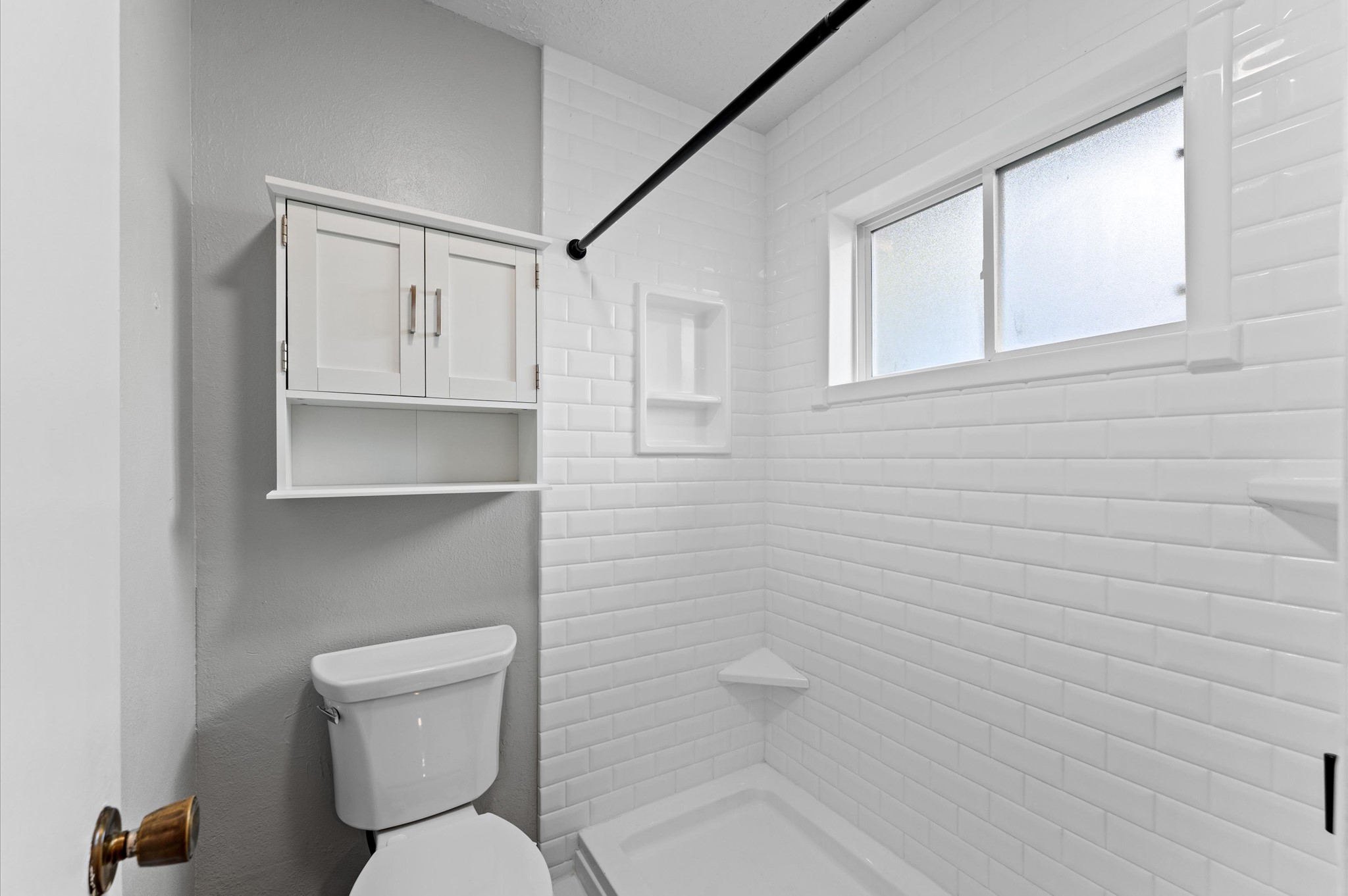 Here is a better view of the primary bath that features a step in shower with built in ledges and a privacy window.