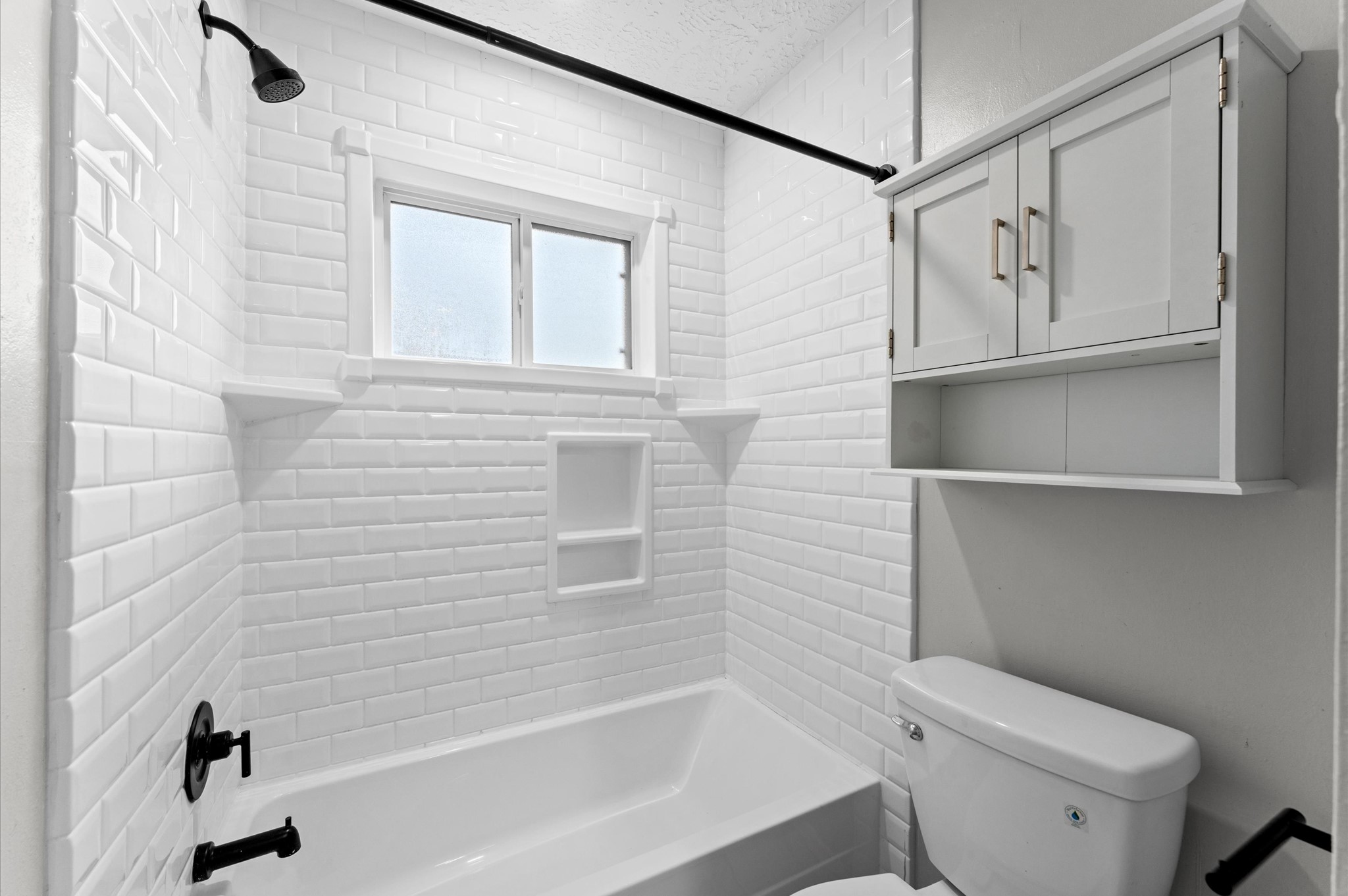 The hall bath features a tile surround tub and shower combination.