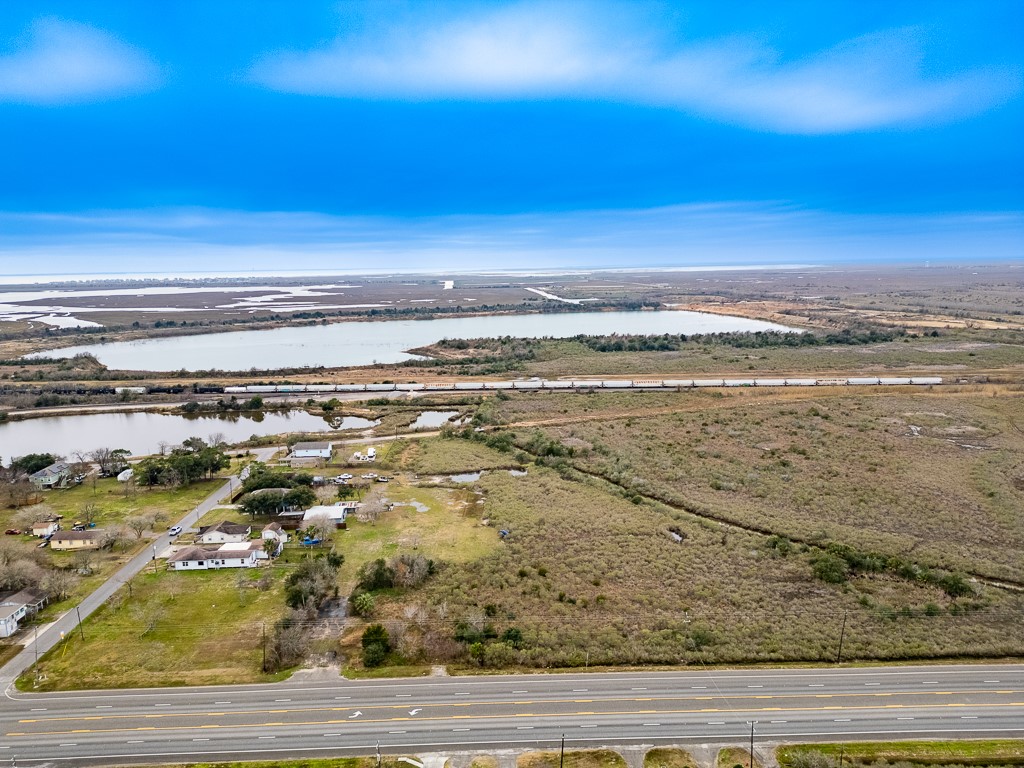 Aerial view of the property along Highway 6 with nearby waterways and rail corridor visible in the distance.