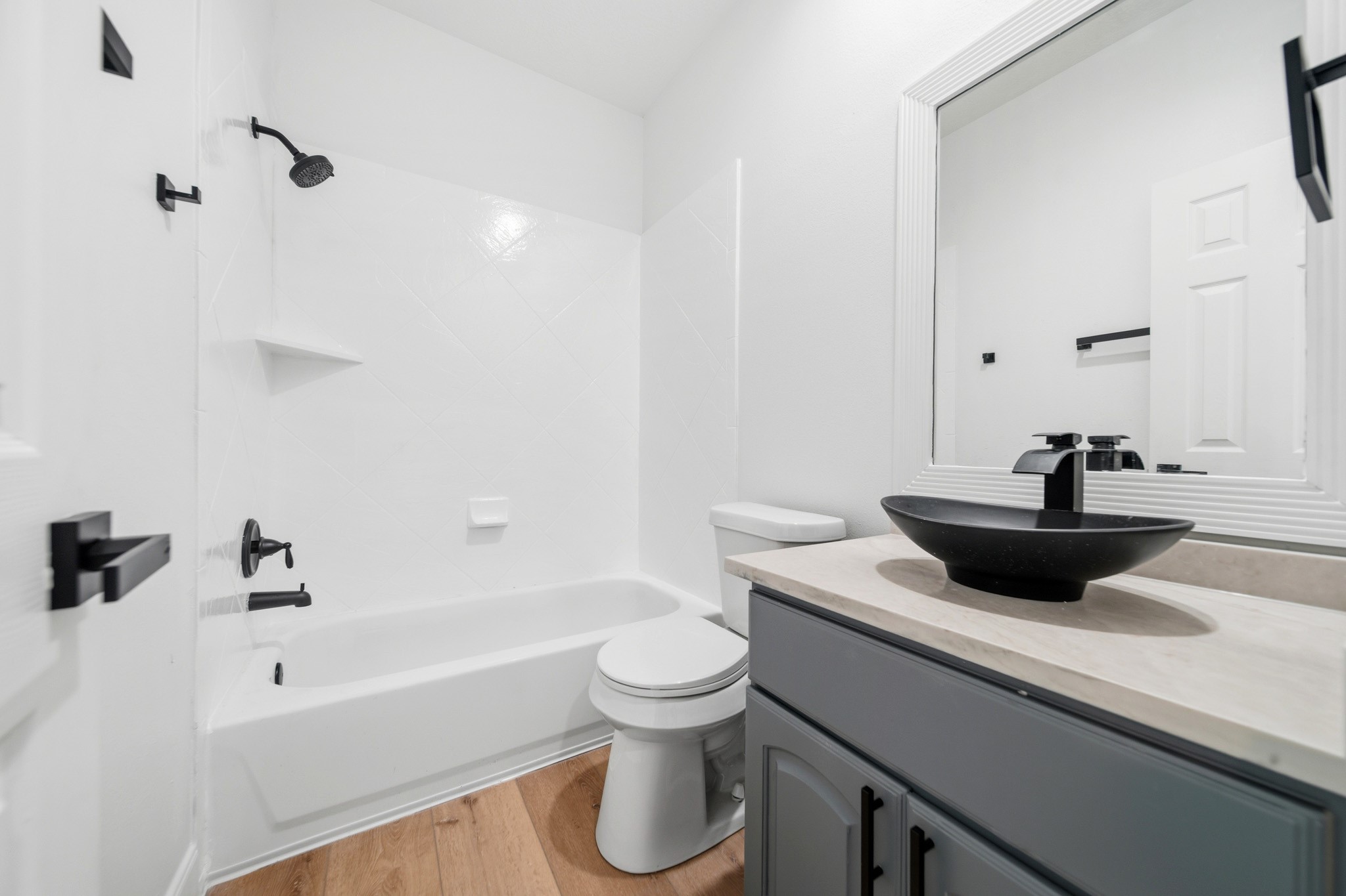 Secondary bath with sleek modern vanity and contemporary black fixtures.