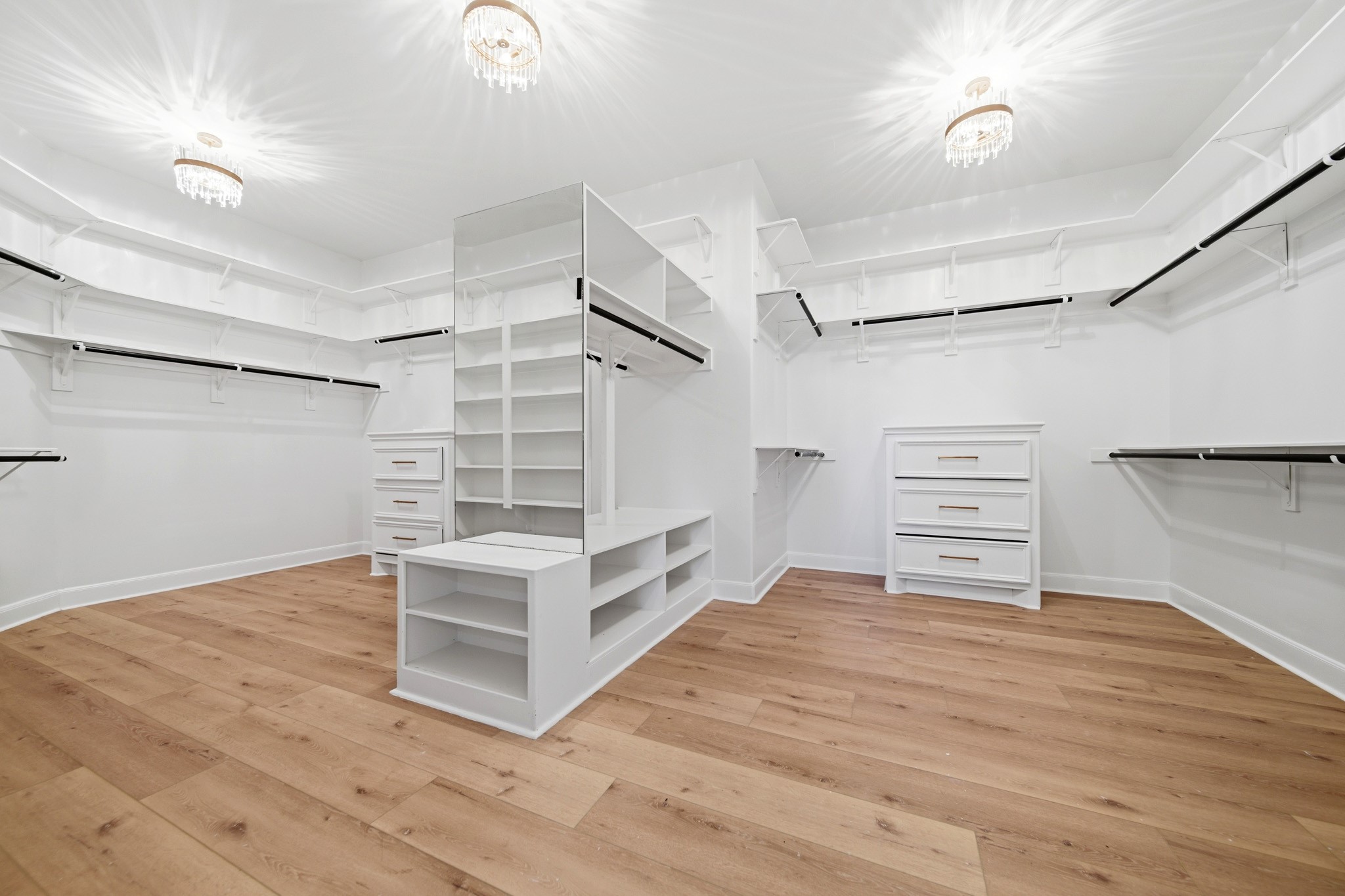Expansive custom walk-in closet with built-ins, storage island, and boutique-style organization.