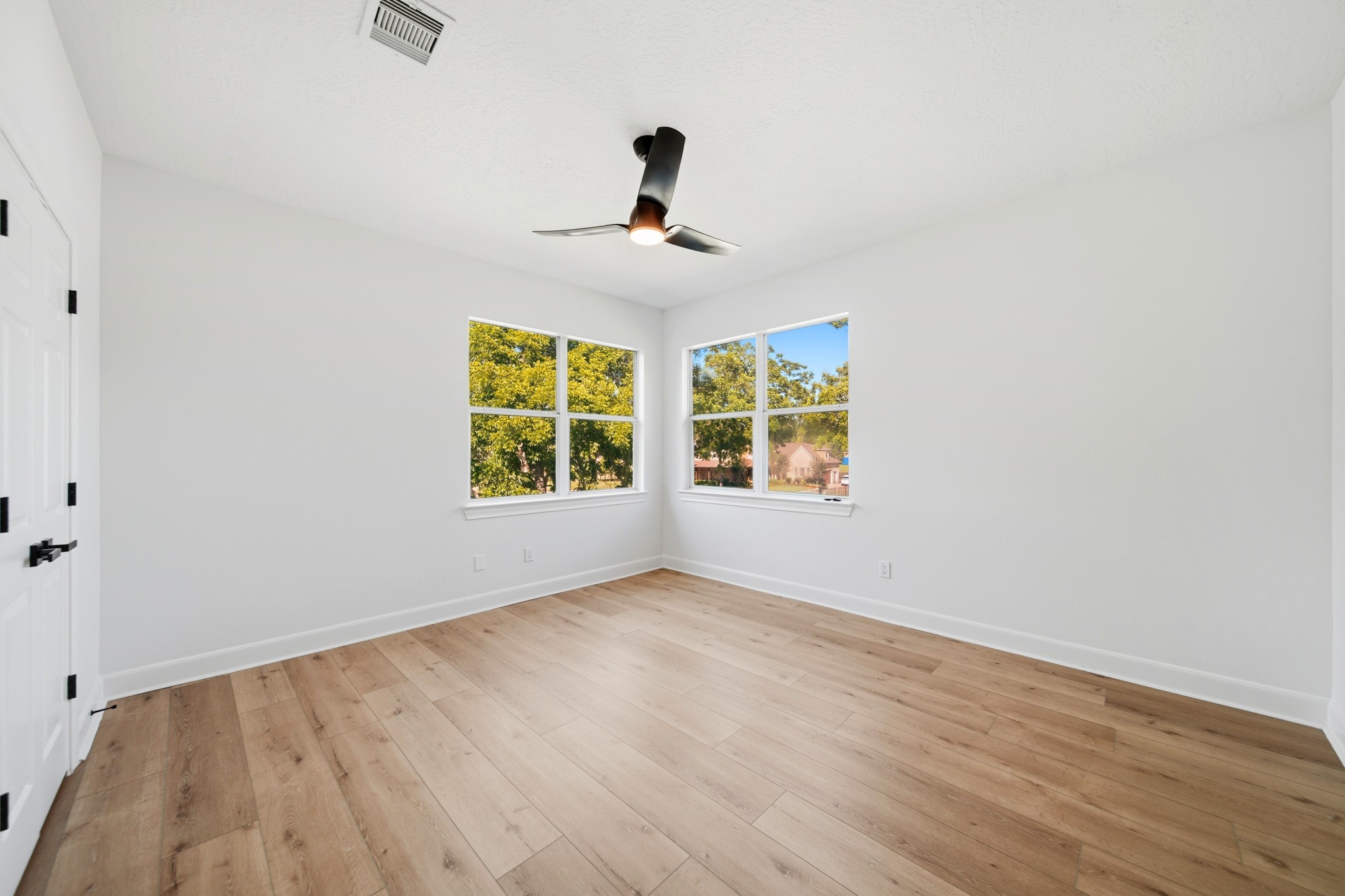 Spacious secondary bedroom with clean lines, oversized windows, and versatile layout.